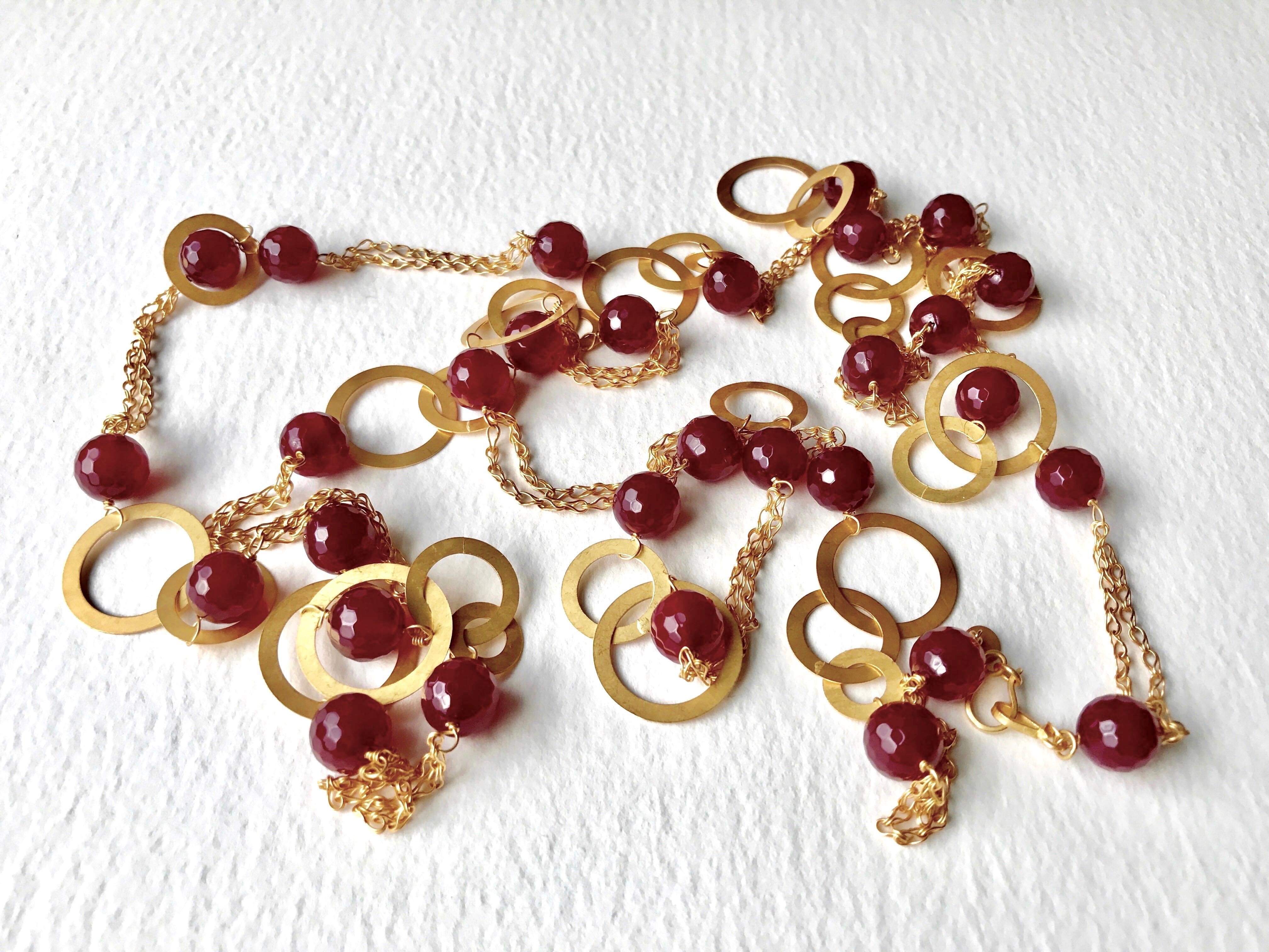 Skilfully handmade solid yellow gold and thirty pieces of cranberry colour agate stones necklace in a satin and patina finish. 
This necklace has a secure hand made clasp and it has been Hallmarked at London Goldsmiths’ Company – Assay Office.
This