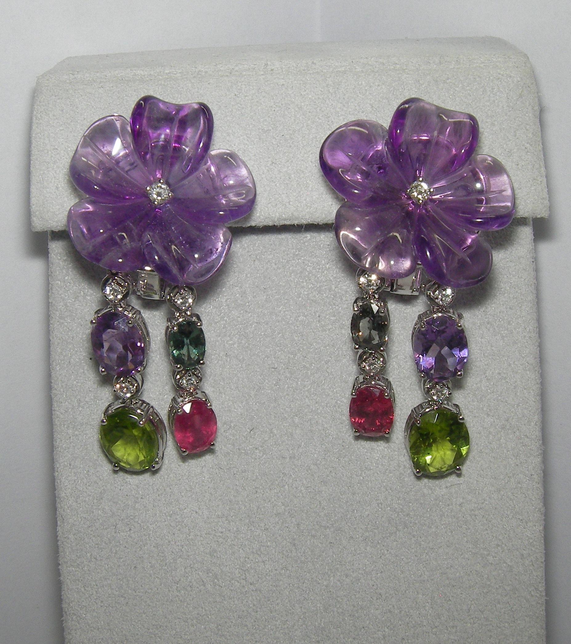 Playful and vibrant 18 Karat white gold earrings. The flower petals are carved out of one entire Amethyst stone. The dropping strands consist of Amethyst, Red Tourmaline, Green Sapphire and Peridot. Each vivid gemstone is elegantly divided with