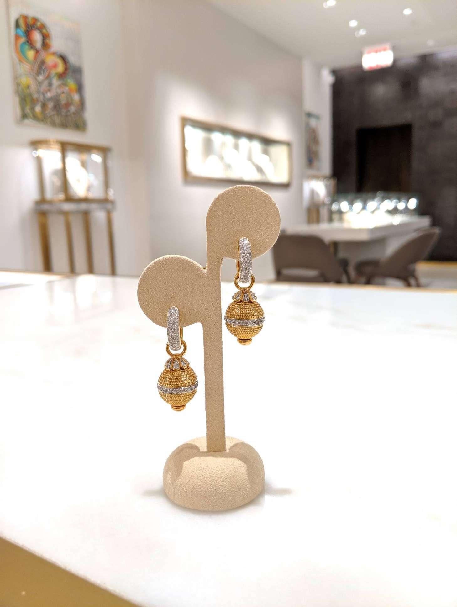 These versatile 18 kt yellow gold earrings can be worn alone as a simple pave diamond huggie or for a more dramatic statement with the beautifully crafted gold and diamond drop.
The total diamond weight is 2.10 carats of F-G color white diamonds.