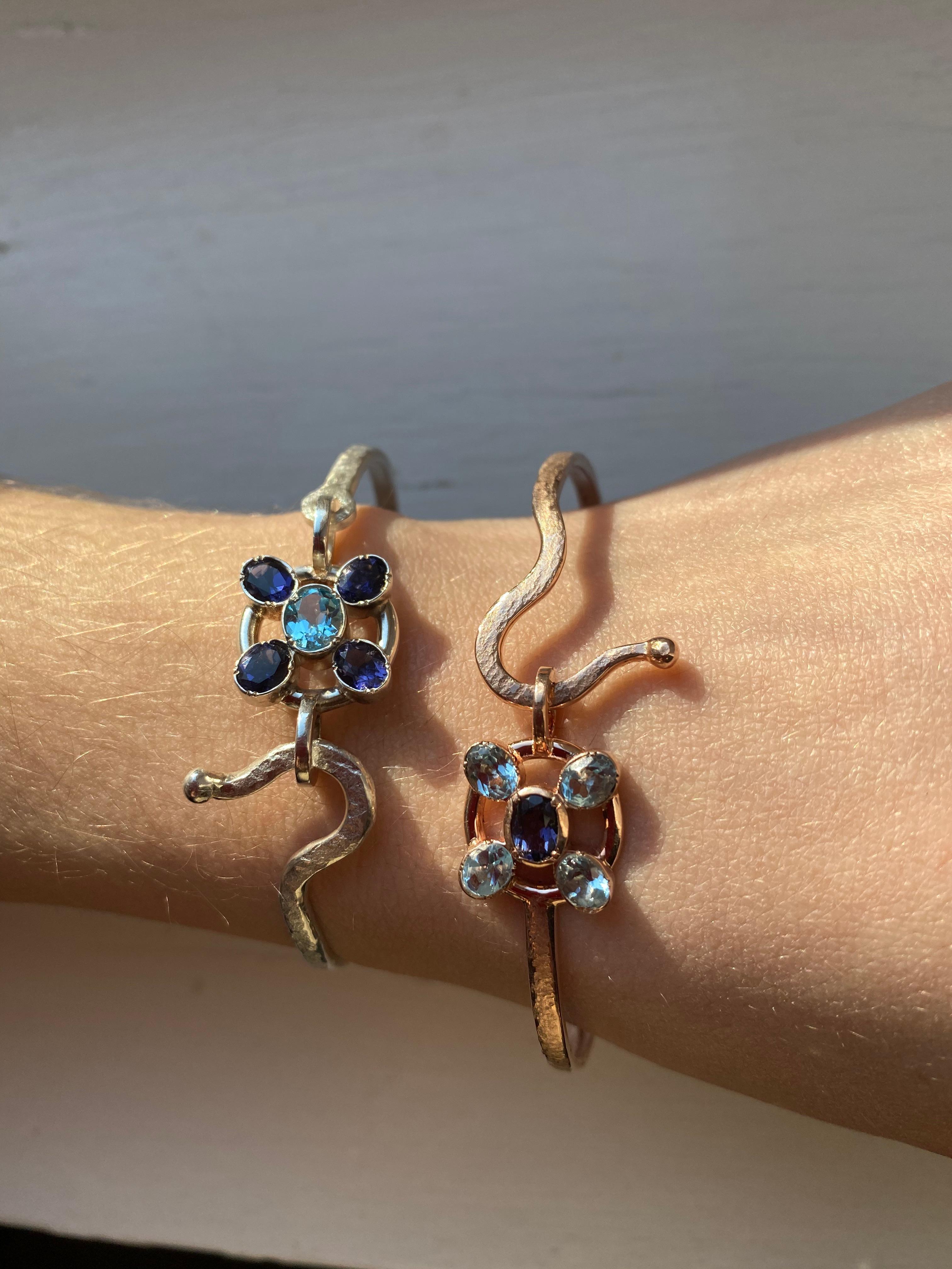 Introducing the exquisite Rossella Ugolini Design Collection, presenting a true masterpiece of jewelry craftsmanship - the handcrafted and hammered 18 Karats Yellow Gold Aquamarine Blue Sapphires Bangle Modern Design Bracelet.  
Crafted with