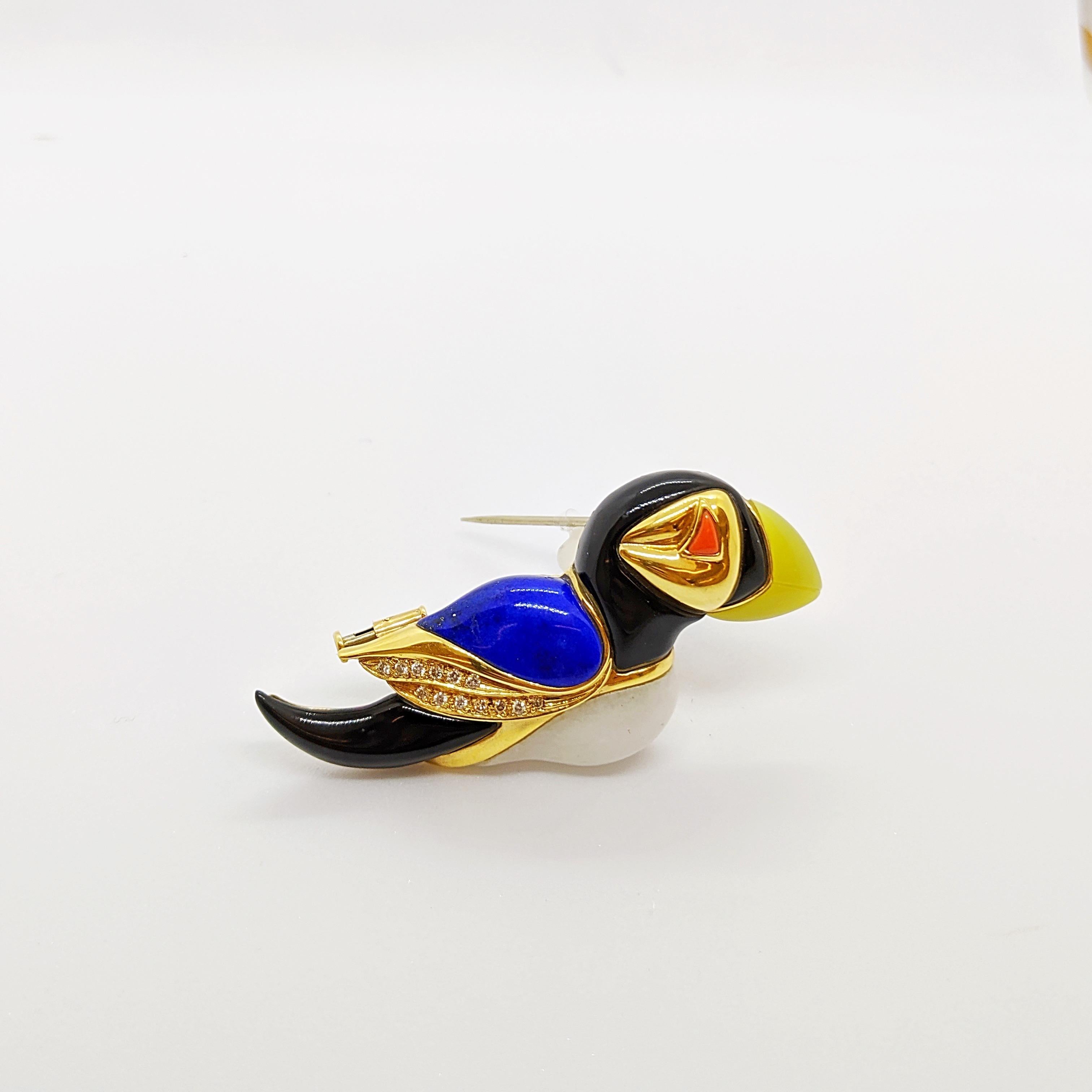 A true work of craftsmanship is the best way to describe this Puffin brooch. Smooth and hand polished stones of Jasper, Lemon Agate, Onyx, and Lapis  form the sculptural birds body. White round brilliant diamonds weighing 0.14 carats are set in the