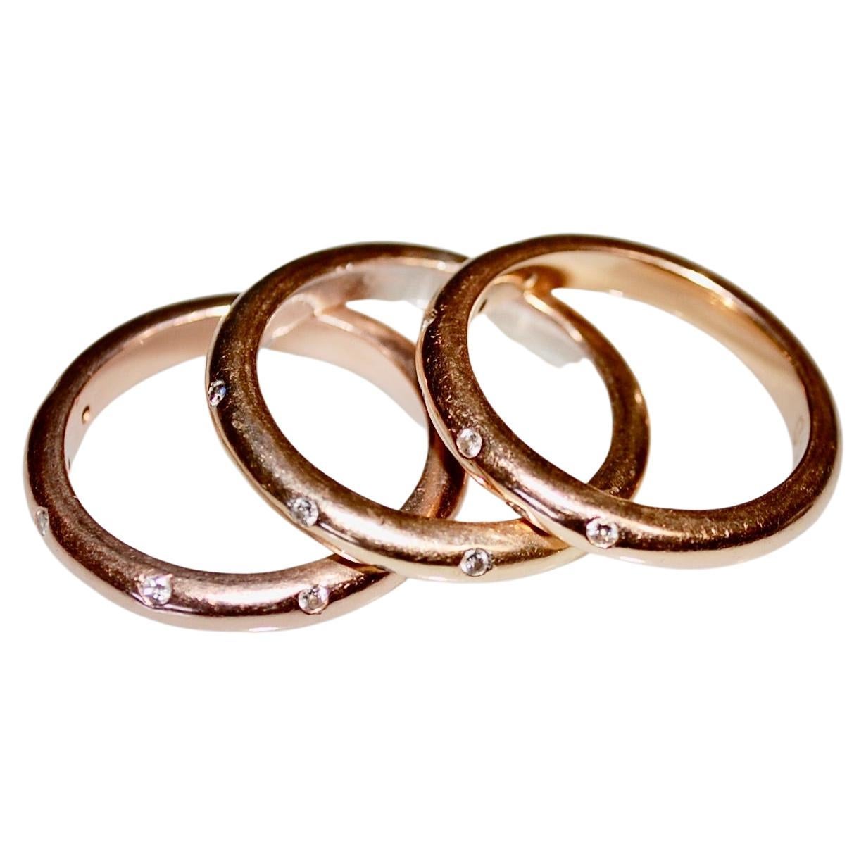 Tiffany style 18k gold three rings set with 6 small round brilliant cut diamonds.
Two rings are in yellow gold and one in rose gold, total weight 15 grams, about 3mm wide, size 7.