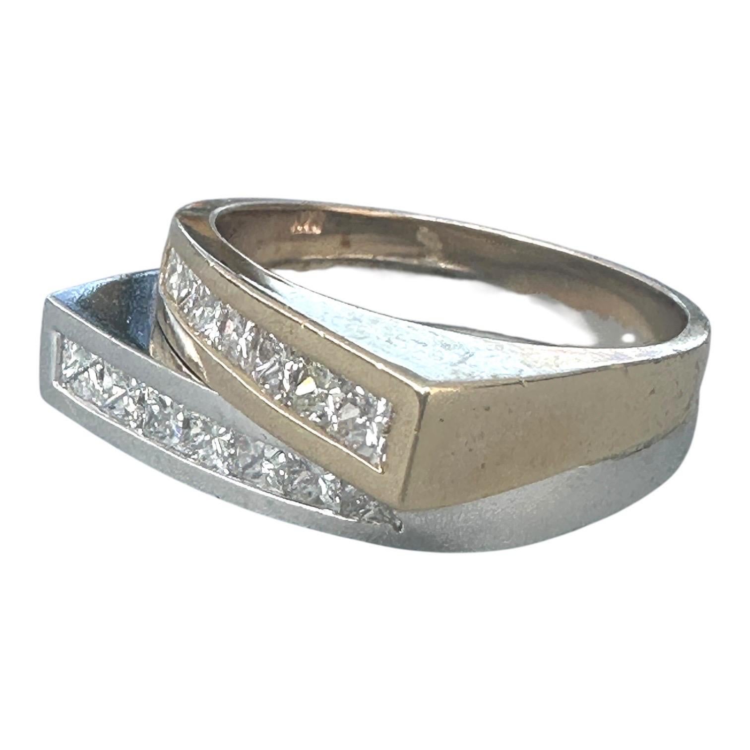 Cette magnifique bague présente 2,00 carats d'étincelants diamants de taille princesse, élégamment sertis en canal sur un anneau moderne de 8,60 mm. Chaque bande est ornée de sept diamants, soit 14 au total. Une bande est fabriquée en or blanc et