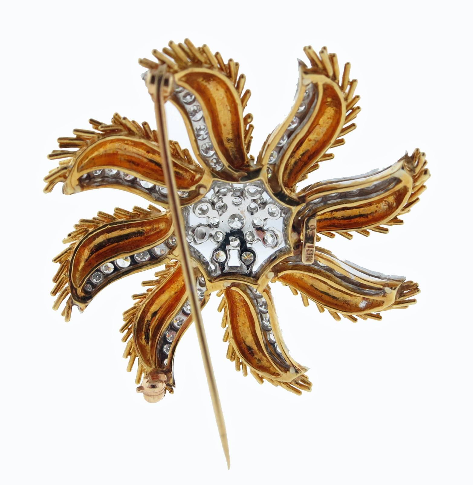 Dazzling quality 18kt. yellow gold brooch in a pinwheel design. The center cluster is prong set in white gold with 16 round brilliant cut diamonds and bead set  with 56 round diamonds radiating from the center. Total diamond weight approx 2.2 cts.
