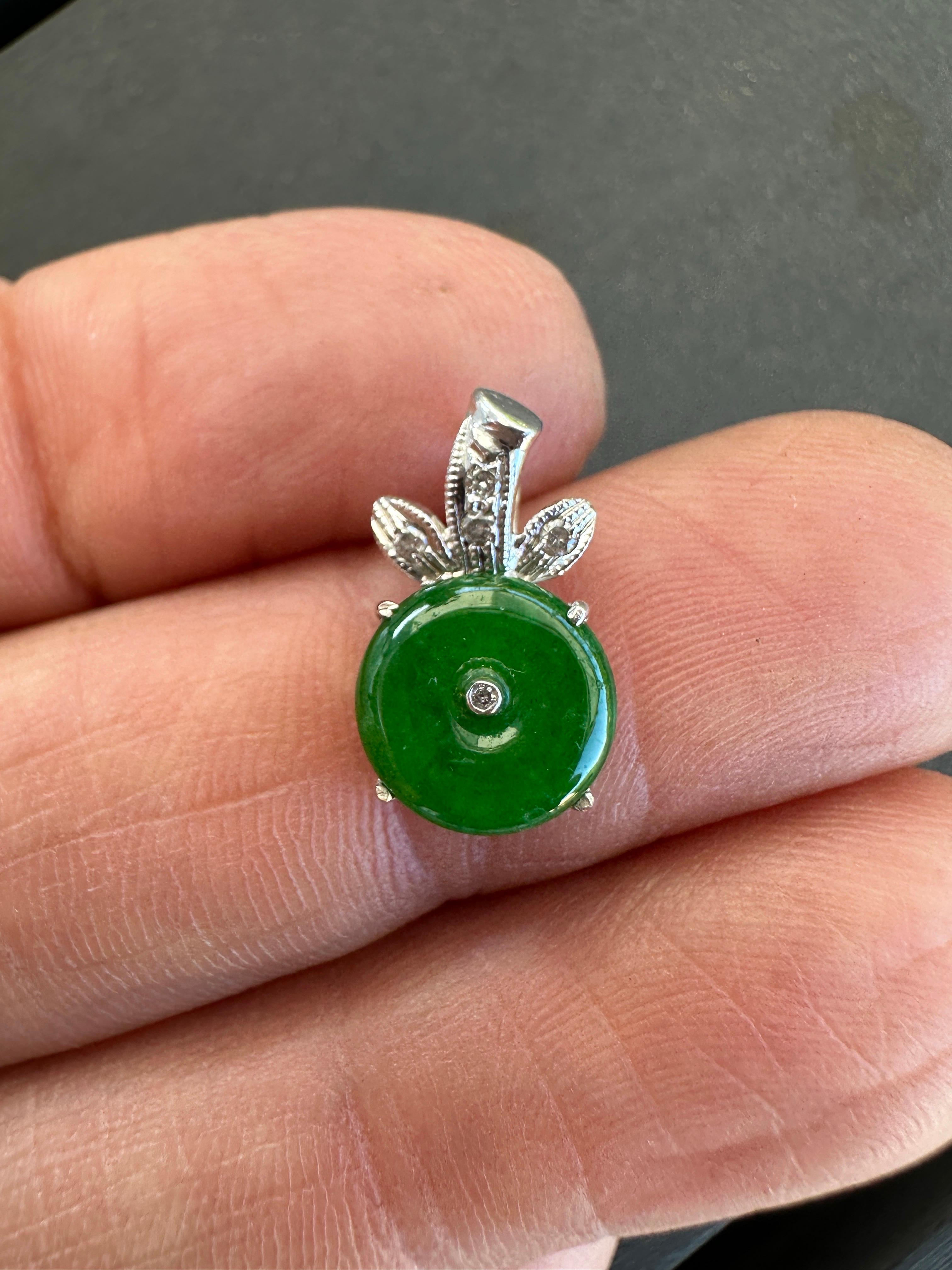 Nessuna descrizione fornita Questo ciondolo a forma di disco di giada e diamante presenta un ciondolo unico a forma di arco con una pietra principale di giada verde naturale incastonata in oro giallo. Il ciondolo include anche un'incastonatura per