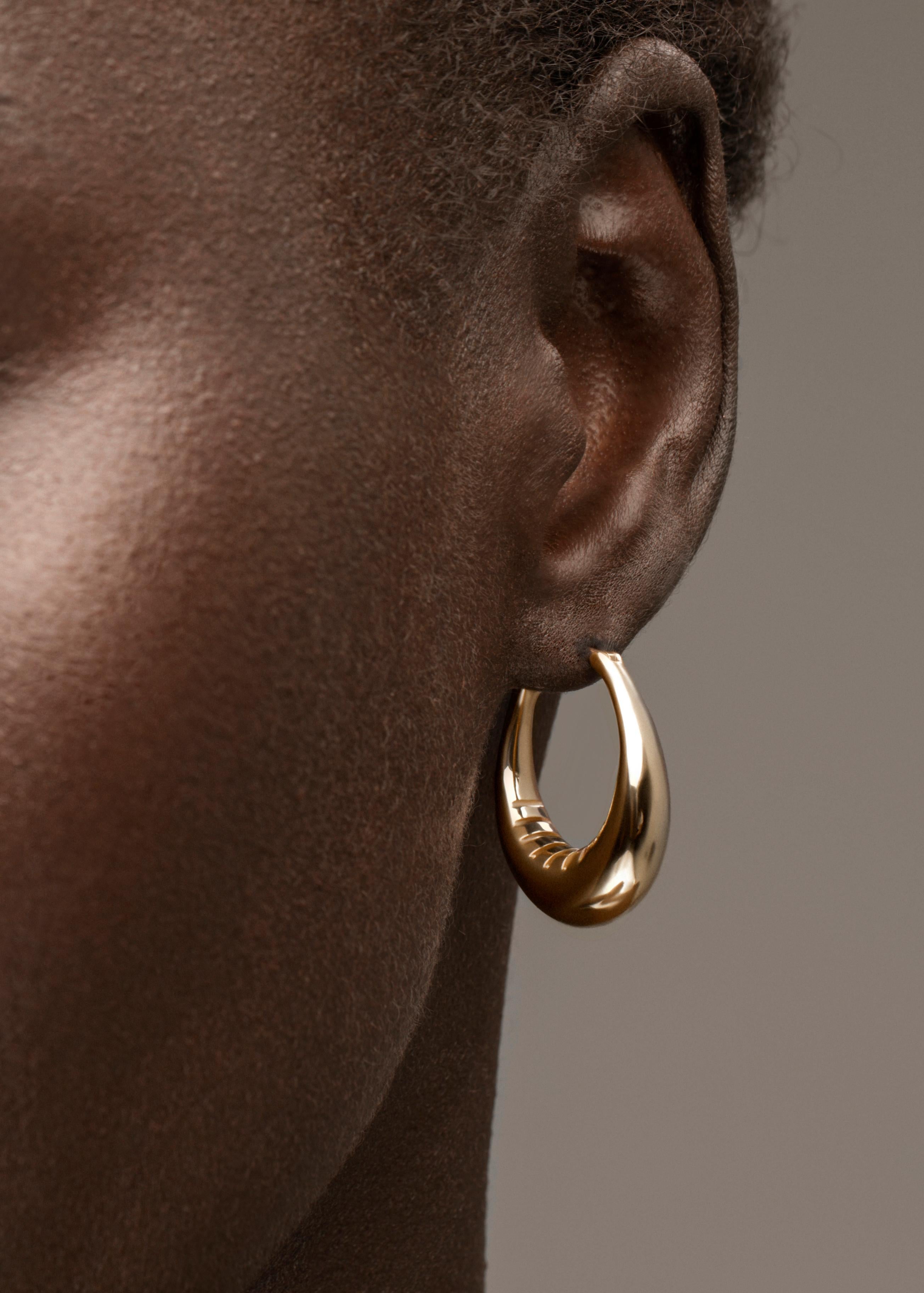 Voluminous Reflective hoops with a stunning interior grille detail. You’ll never want to take these off.

Handcrafted in NYC with 18kt certified Fairmined Ecological gold that is toxic chemical free, sustainable, ethical and clean.

Please allow 3-4