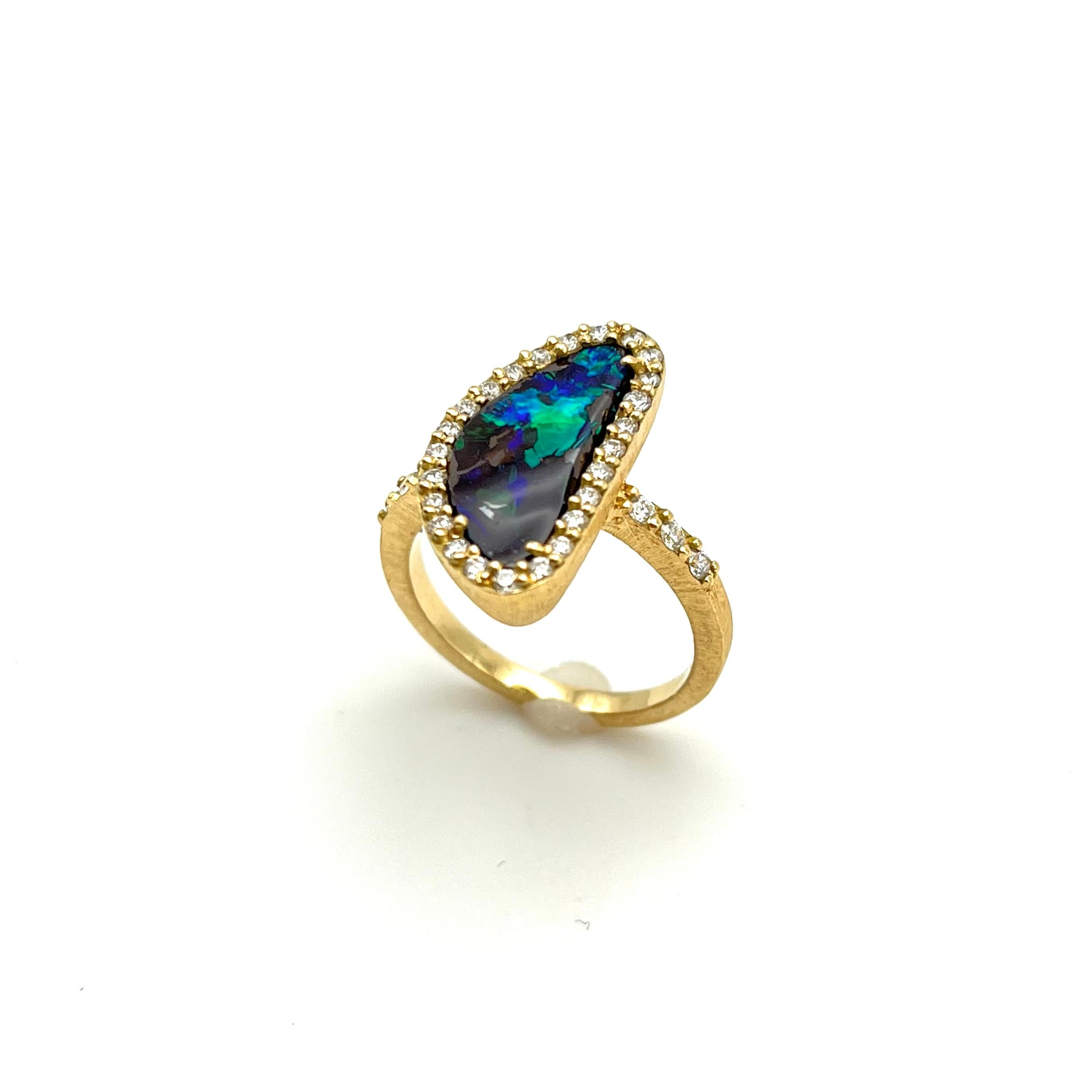 Dieser Ring ist reich an Farbkontrasten. Die leuchtenden, kühlen Töne des Opals ergänzen die warme, 18-karätige Goldfassung. Dieser Ring wurde von einem Familienjuwelier in der Nähe von Florenz, Italien, handgefertigt. Jede Linie dieses Rings wurde