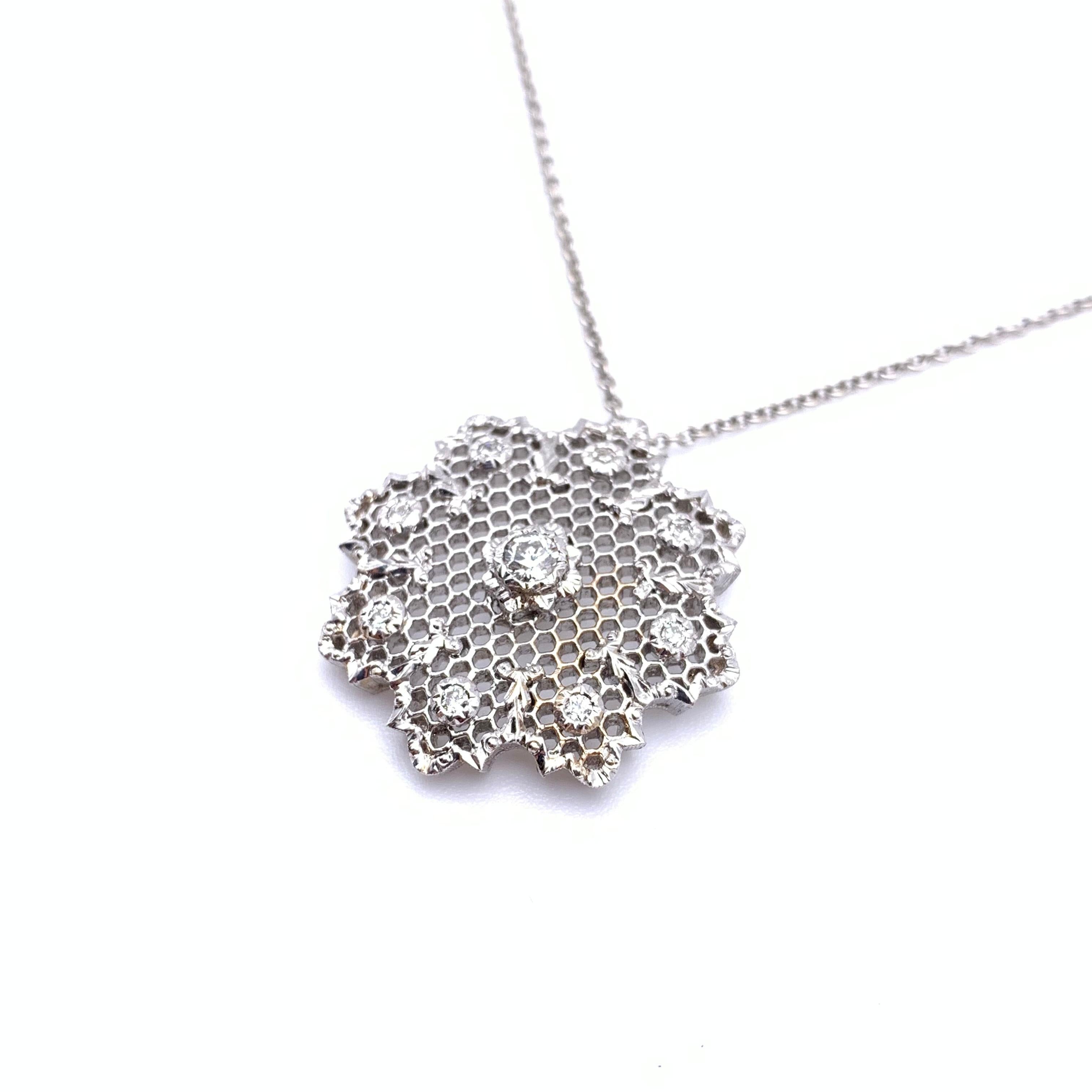 This elegant necklace channels holiday cheer with its snowflake-like sparkle and ribbon accents around the parameter of the pendant. It was handmade by a family jeweler outside of Florence, Italy out of solid, 18-karat white gold with each detail