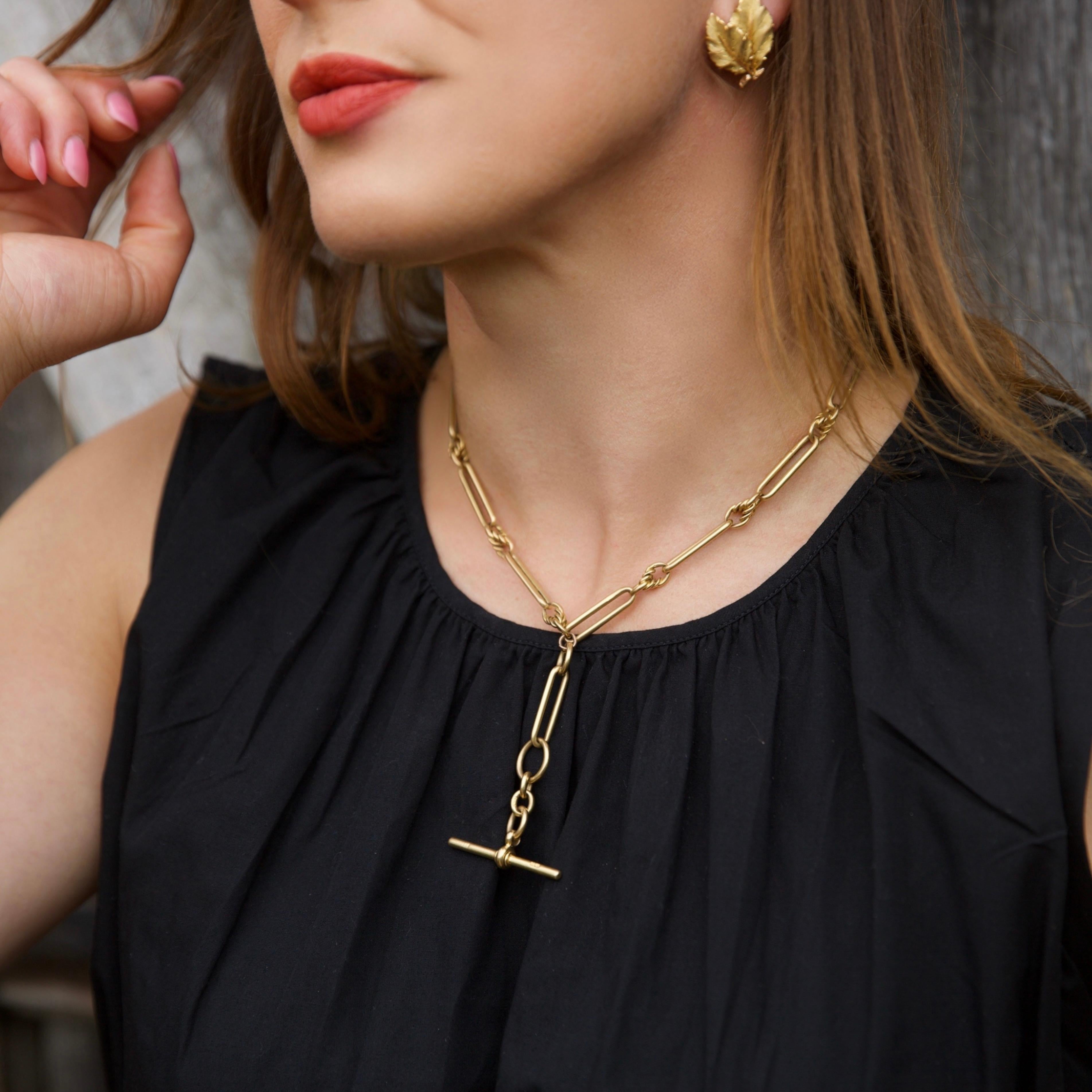 Albert chain Paperclip / Trombone link necklace crafted in 18 karat yellow gold. This piece features elongated bar links alternating with twisted gold connectors, offering a refined yet bold silhouette. The chain is fitted with a T-bar and dog clip