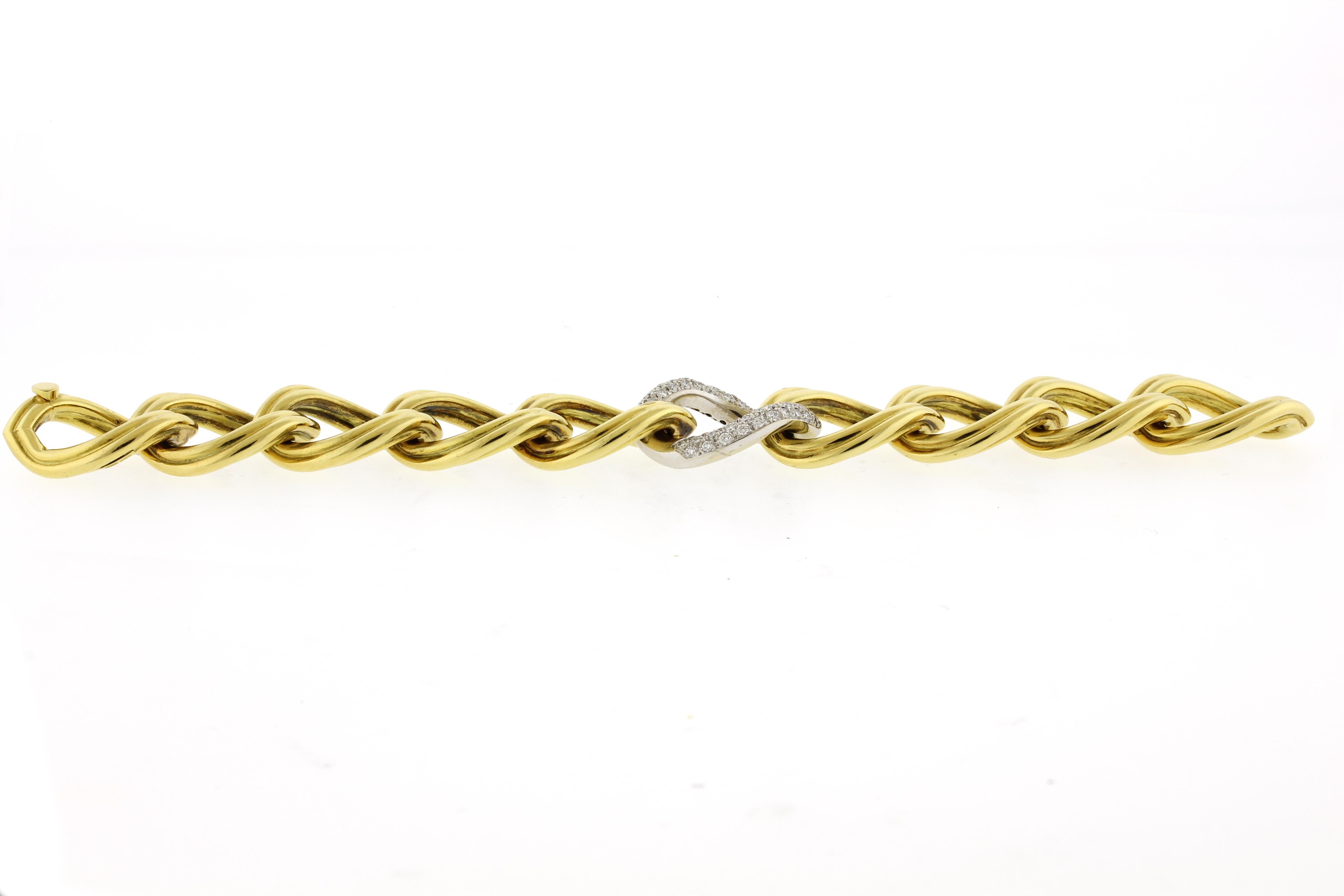 This 18-karat yellow and white gold bracelet features fluted large oval links and one center with pave diamonds.  The diamonds are G color and VS clarity.
♦ Metal: 18 Karat
♦ Length: 8 inches
♦ Width: 3/4 of an inch
♦ Diamonds: 70=1.66cts
♦ Weight: