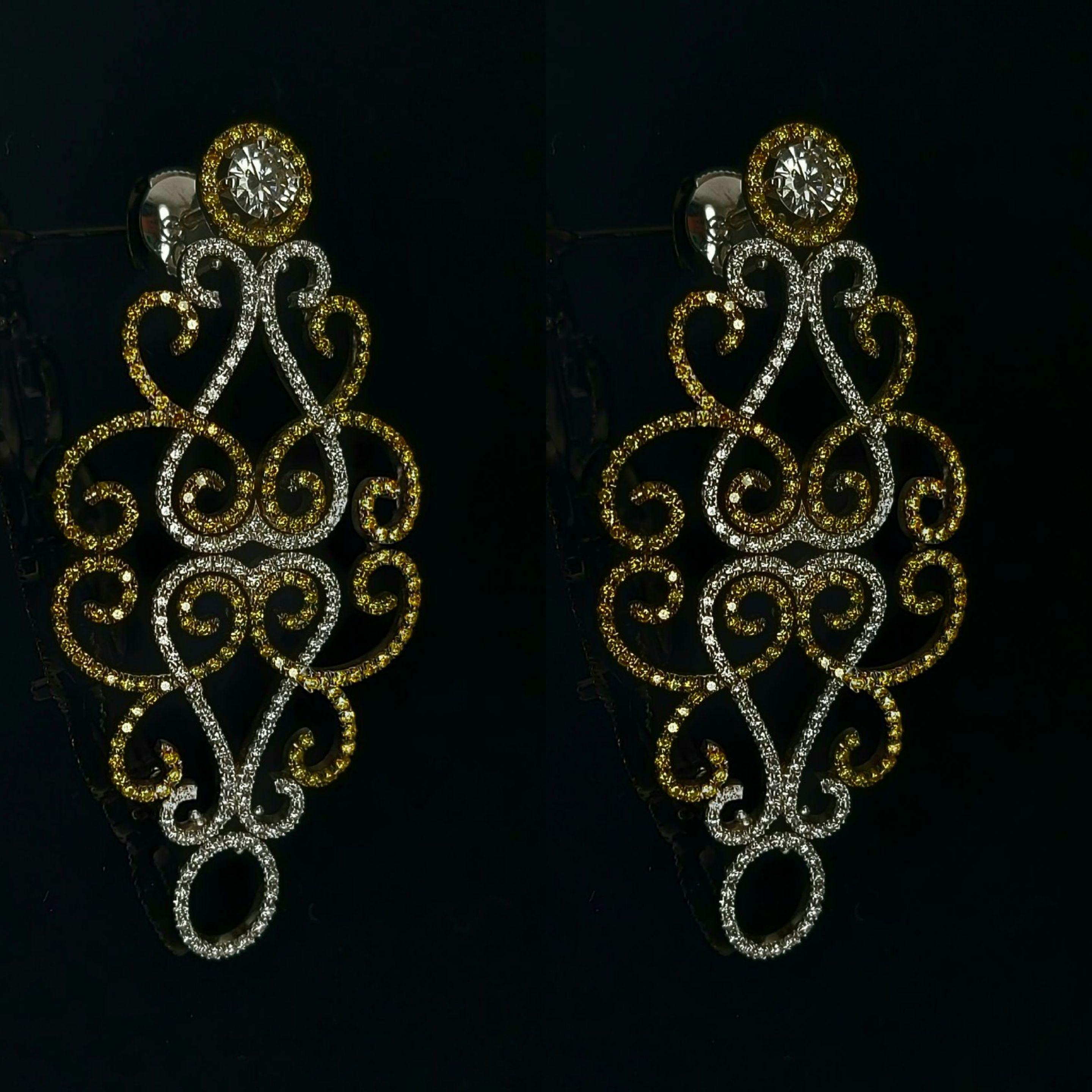 Very elegant 18 kt white gold chandelier earrings set with fancy yellow and white diamonds and one large solitaire diamond. 

Diamonds: Yellow & white brilliant cut diamonds, together ca. 3.17 cts, large solitaire diamonds in the center 0.91