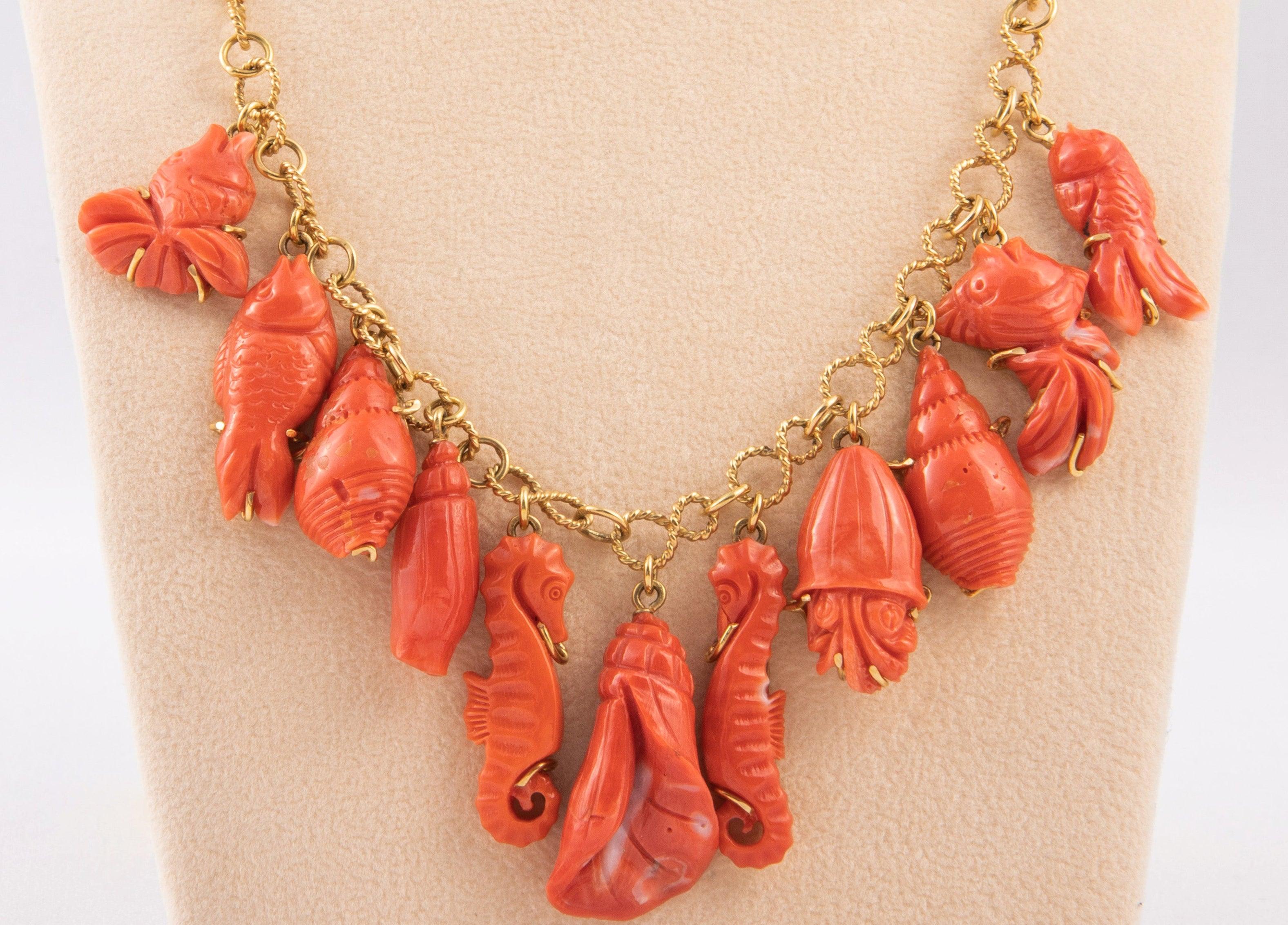 18 kt gold link necklace with 11 hand engraved coral dangle charms depicting marine theme: shells ,sea horses, jellyfish and fish.
Italian manufacture 1990. weight 53gr total.