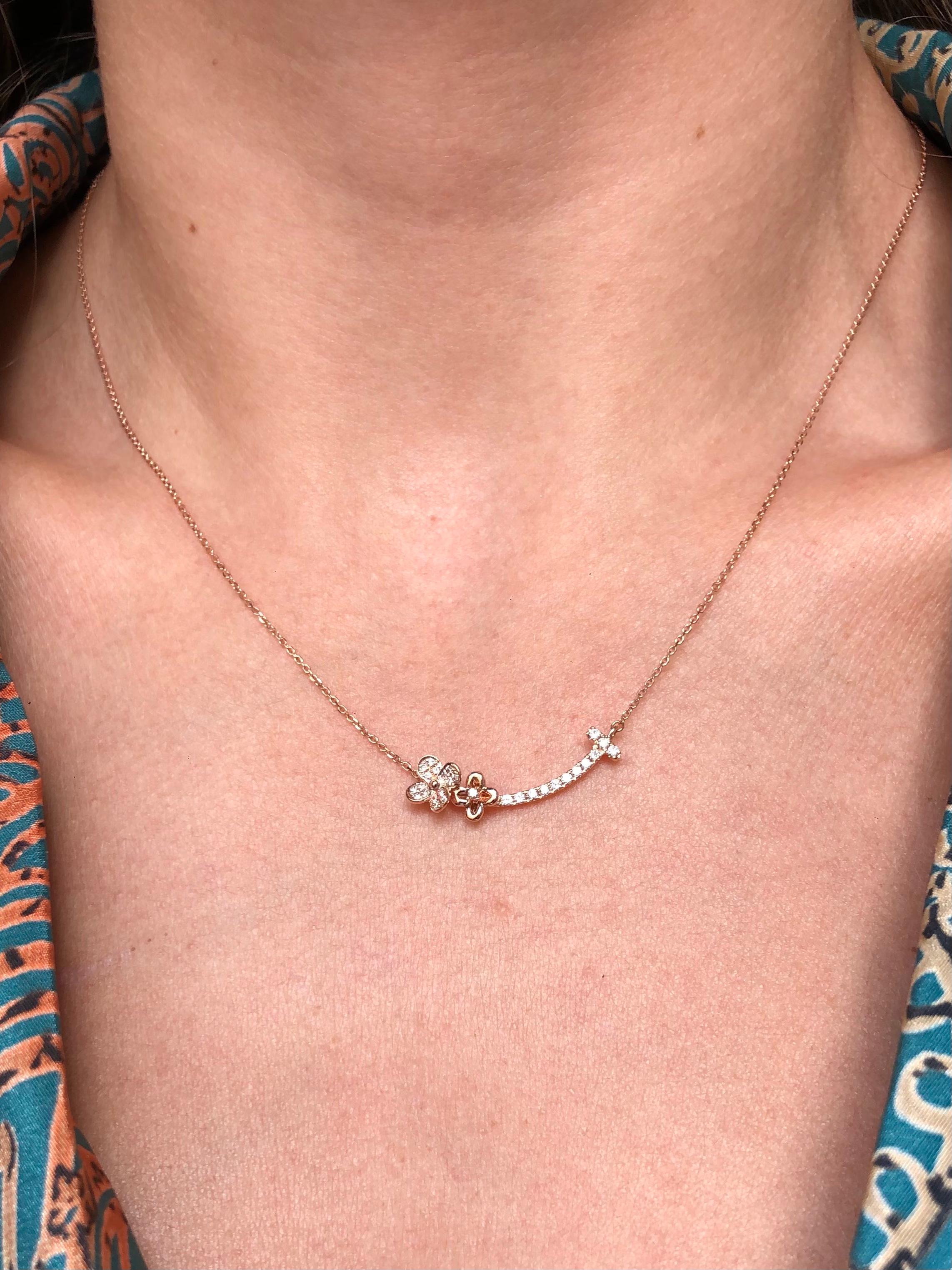 Lascia che il tuo stile risplenda con la combinazione scintillante del Fiore a grappolo di diamanti e del Fiore d'oro solitario, esposti in una collana con pendente a barra curva in oro rosa/bianco scintillante.

Un po' di scintillio è il tocco