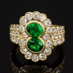 2 Oval Emeralds and Diamond 18-Karat Gold Halo Ring