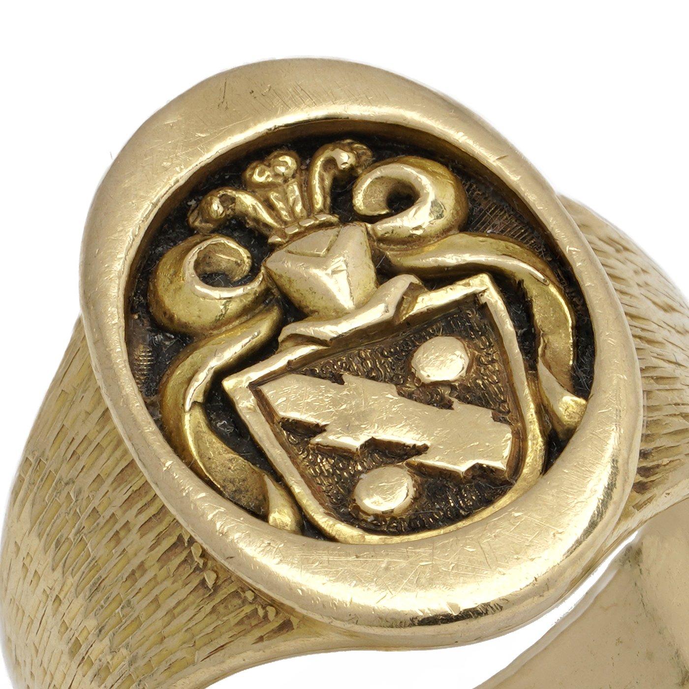 Anello con sigillo in oro giallo 18kt, con stemma di famiglia profondamente intagliato che raffigura uno scudo araldico con elmo coronato e manto decorativo. 

Specifiche: 
Materiale: Oro giallo 18kt (marcato 750)
Peso: 10 grammi
Taglia delle dita: