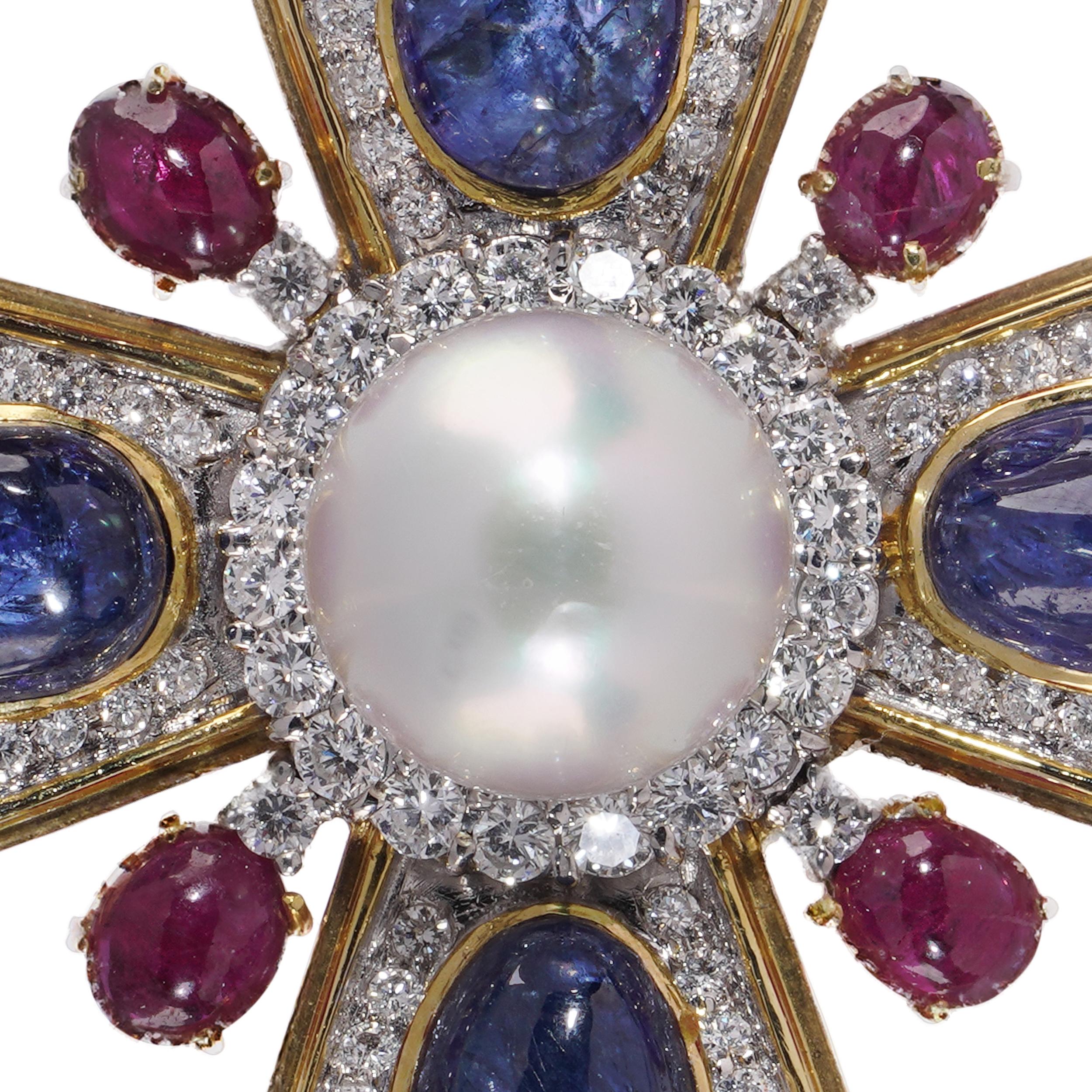 A magnificent Maltese cross brooch crafted in a striking combination of 18kt yellow and white gold, featuring a rich array of coloured gemstones and diamonds. This large and opulent jewel centres on a lustrous white pearl, encircled by brilliant-cut