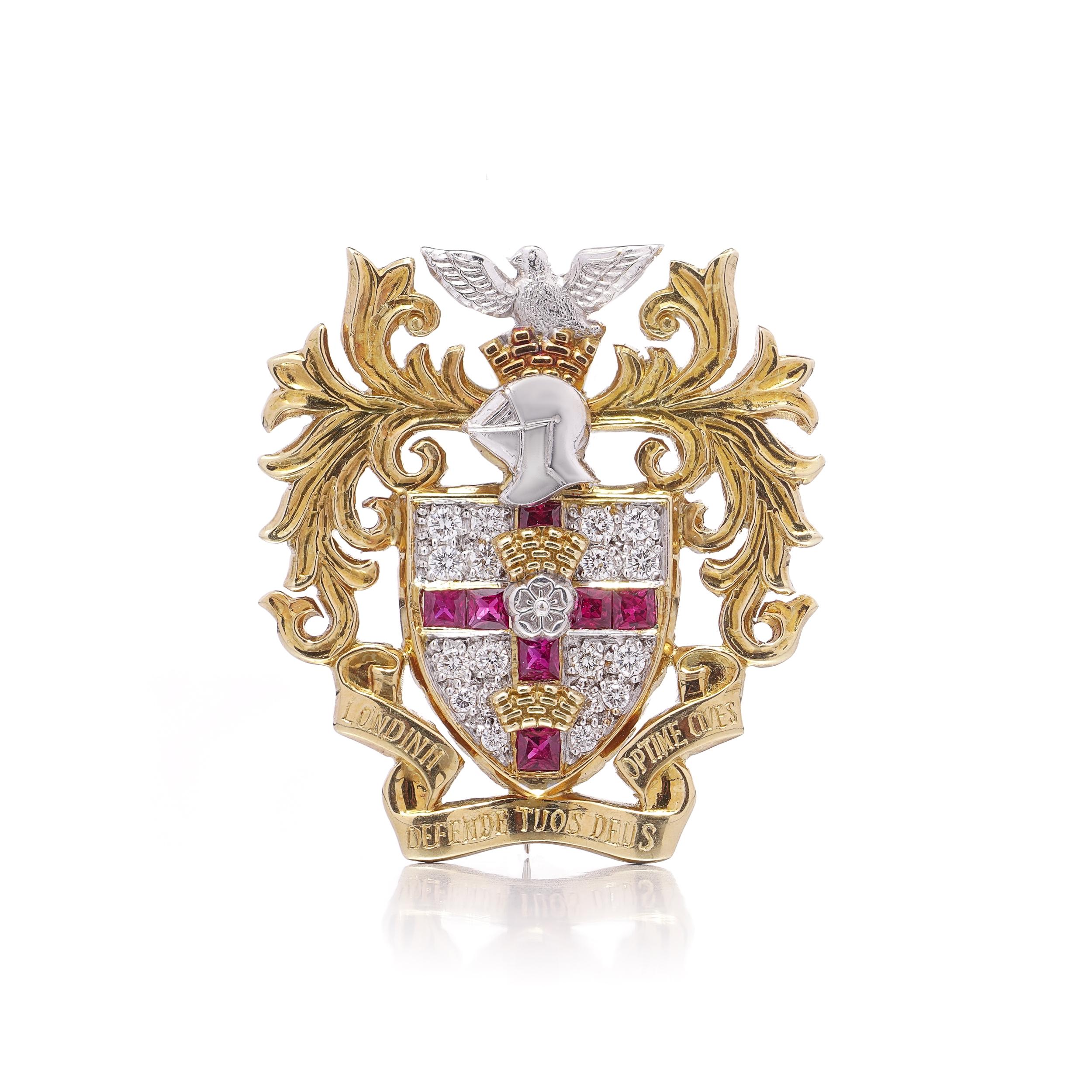 Una straordinaria spilla araldica in oro giallo e bianco 18kt, finemente lavorata con il disegno di uno stemma di famiglia in rilievo con l'iscrizione latina 