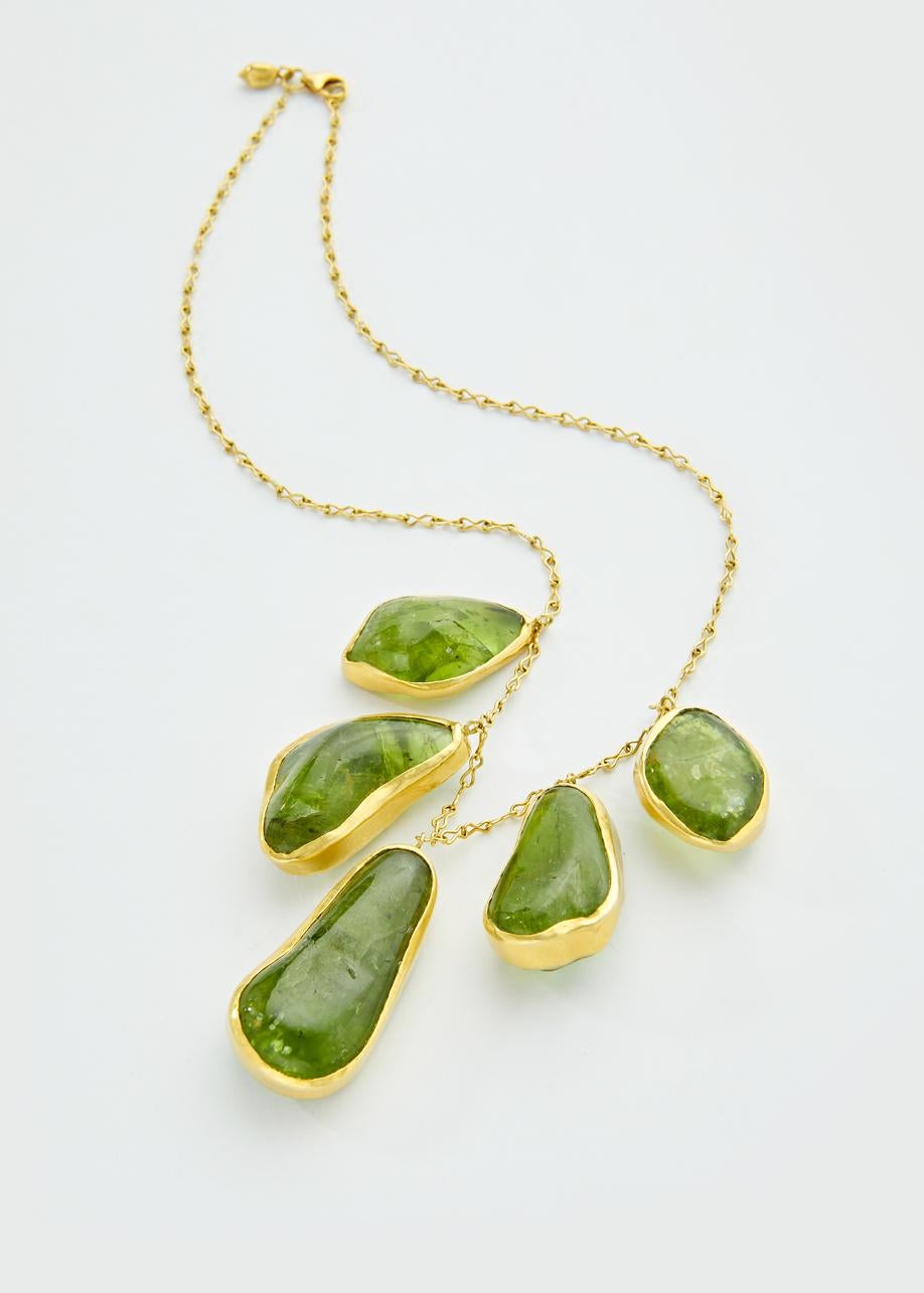 Five large hand-cut peridot gems with a deep irregular cut following the stone's natural shape, set in a gold chain, a one-of-a-kind piece.

Olive green peridot, is rare in its large size and found in Myanmar. This beautiful stone was prized by the