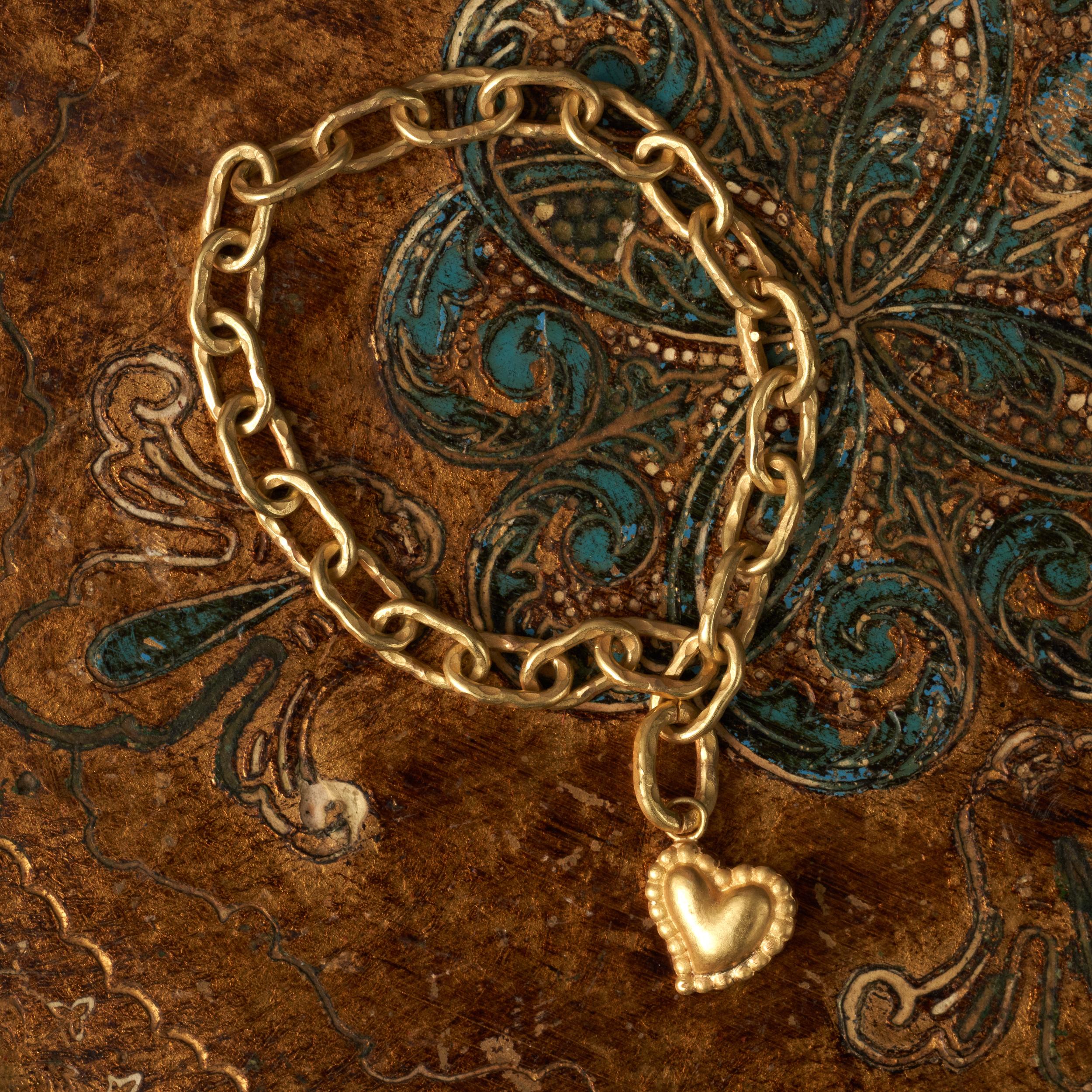 Heavy 18kt gold hand hammered link chain with a hidden click looped fastening. Hangs with a detachable solid 18kt gold scared heart pendant. The chain measures 7”.

Symbolism:
The sacred heart symbolises eternal, undying love and