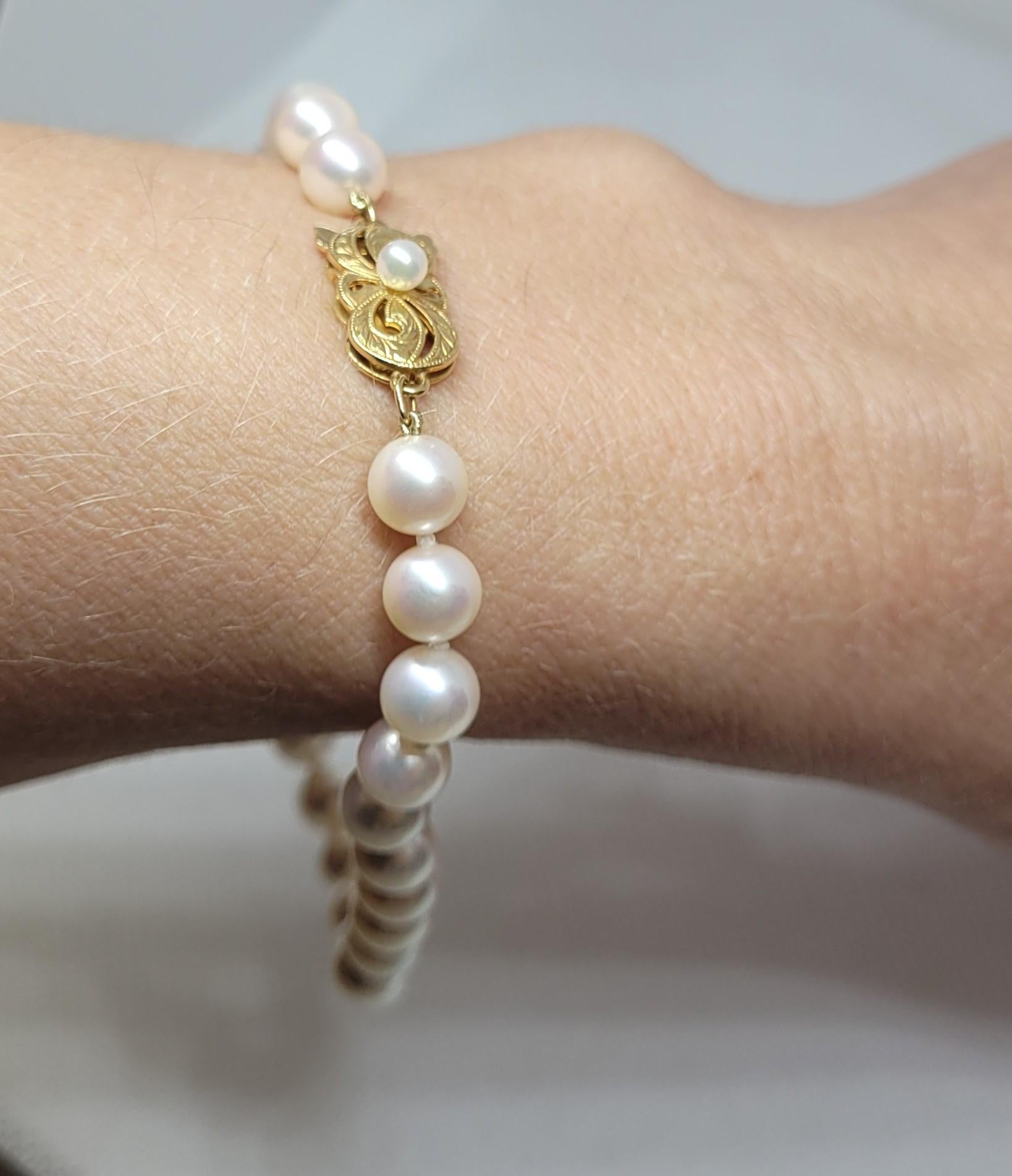 Gorgeous 18kt gold Mikimoto necklace and bracelet set featuring a 32-inch, 6.6mm pearl necklace and a 9.25-inch, 6.6mm pearl bracelet, both secured with bow-style, 18kt yellow gold pearl clasps. The pearl clasps are beautifully hand-engraved and