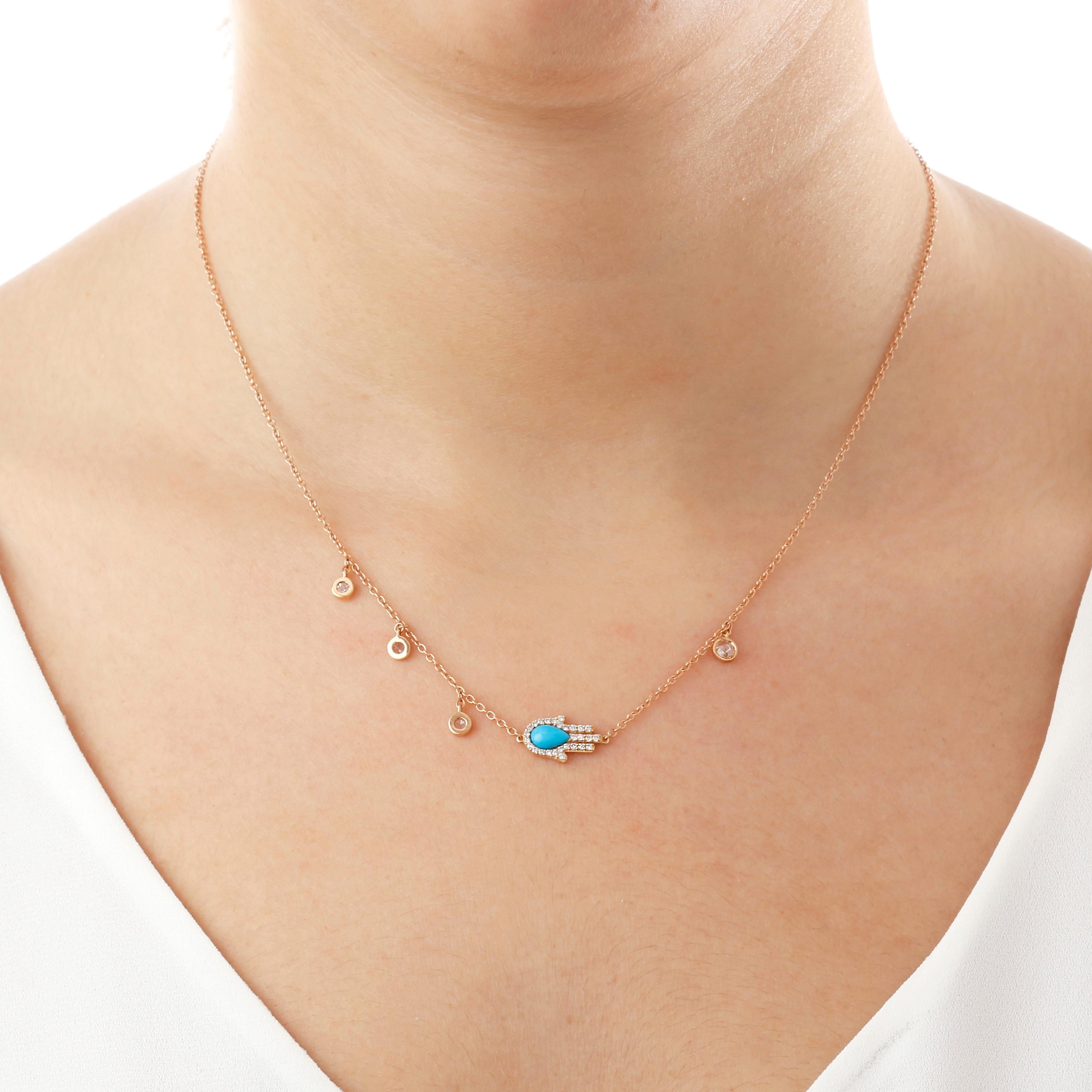 This necklace is crafted in 18kt rose gold and features a diamond and turquoise hand pendant. The hand symbolizes protection and good luck, making this necklace both stylish and meaningful. The hand is adorned with sparkling diamonds, adding a touch