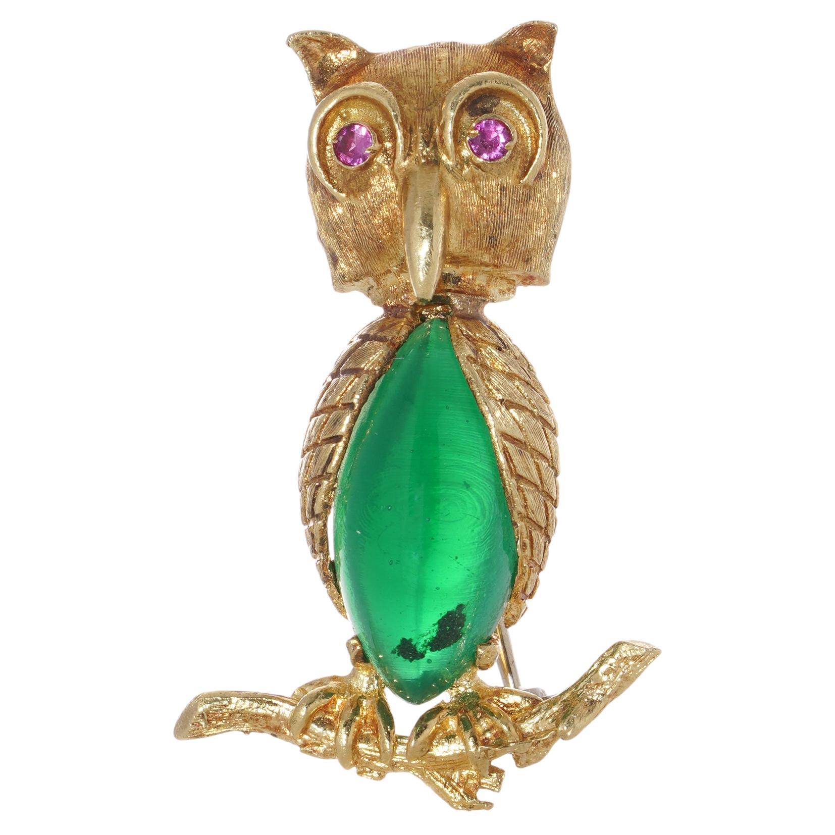 18kt gold owl brooch standing on a branch with coloured glass body and ruby eyes