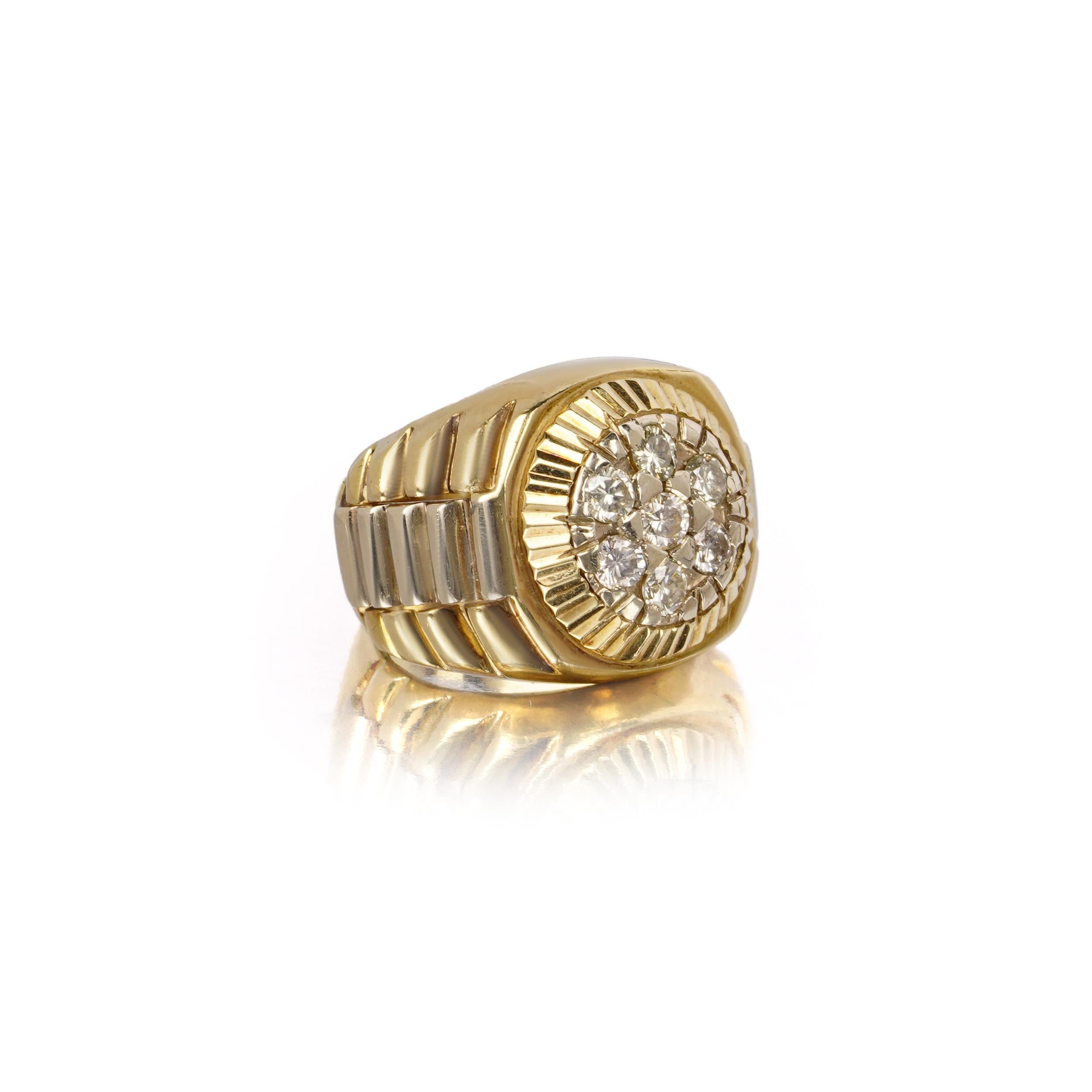 Ein kühner und skulpturaler Ring im Stil einer Vintage-Rolex aus 18-karätigem Gelbgold mit einem kreisförmigen Brillantcluster. Sieben runde Diamanten im Brillantschliff (je ca. 0,10 Karat) sind zentral in einer gerippten Einfassung im