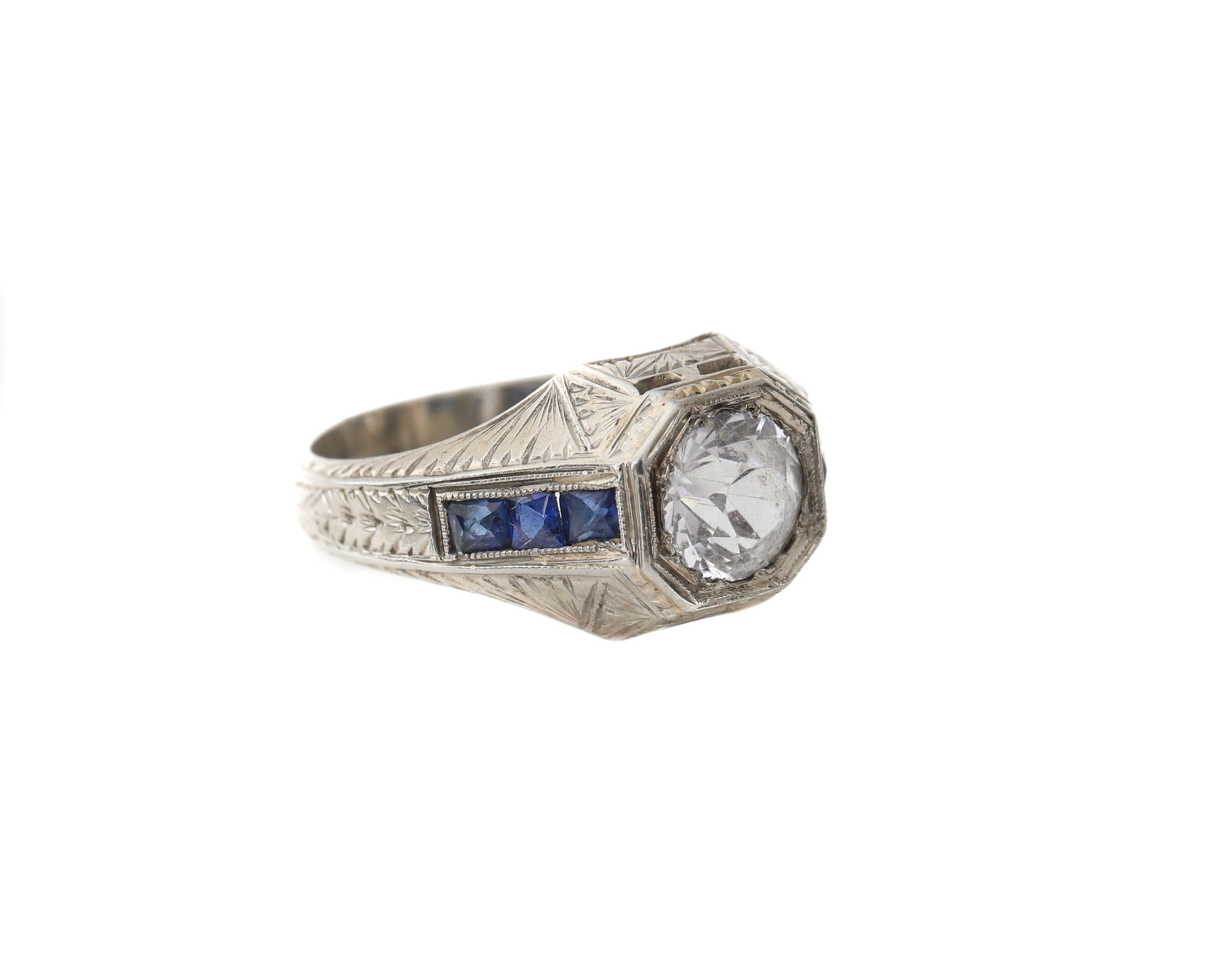 Here we have a very unique offering! Genuine 1930's Art Deco style men's ring with old european cut white sapphire center in a highly engraved ring. The 18 karat white gold ring is decorated with an evenly spaced etched design throughout the band