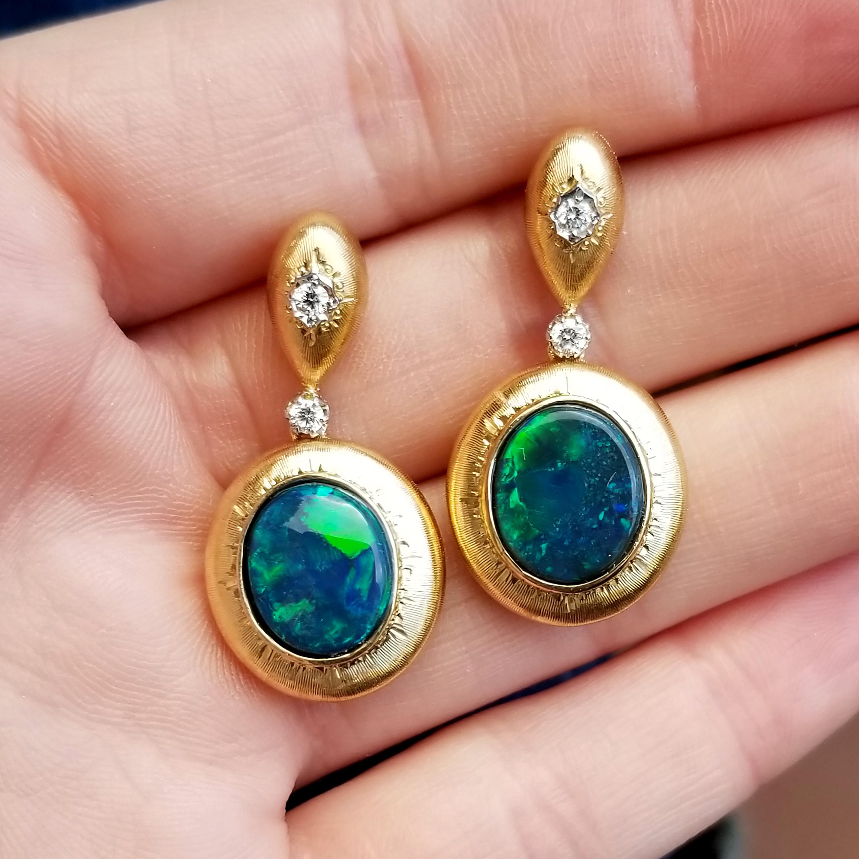 These intense deep blue, green, and turquoise black opals (sourced from the famed Lightning Ridge in Australia) have rich play of color over the entire surface of the stones. From any viewing angle, the view is magical and magnificent. This pair of