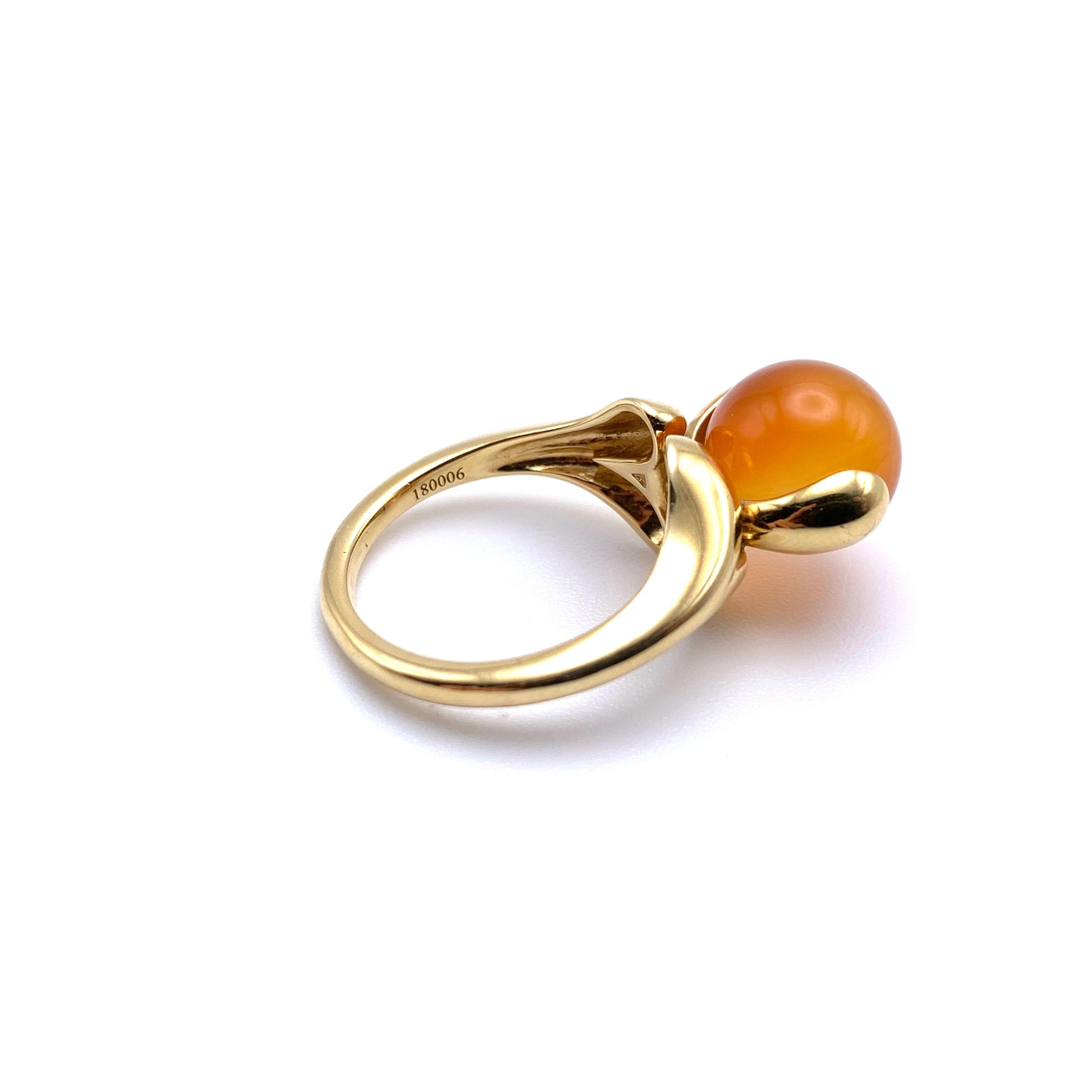Dieser stilvolle Modering wurde von der italienischen Designerin Marina Bulgari entworfen. Er ist in massivem 18-karätigem Gelbgold gefasst und hat einen Karneol in Spannfassung als Mittelstein. Die Perle dreht sich, wenn sie gedreht wird, und fängt