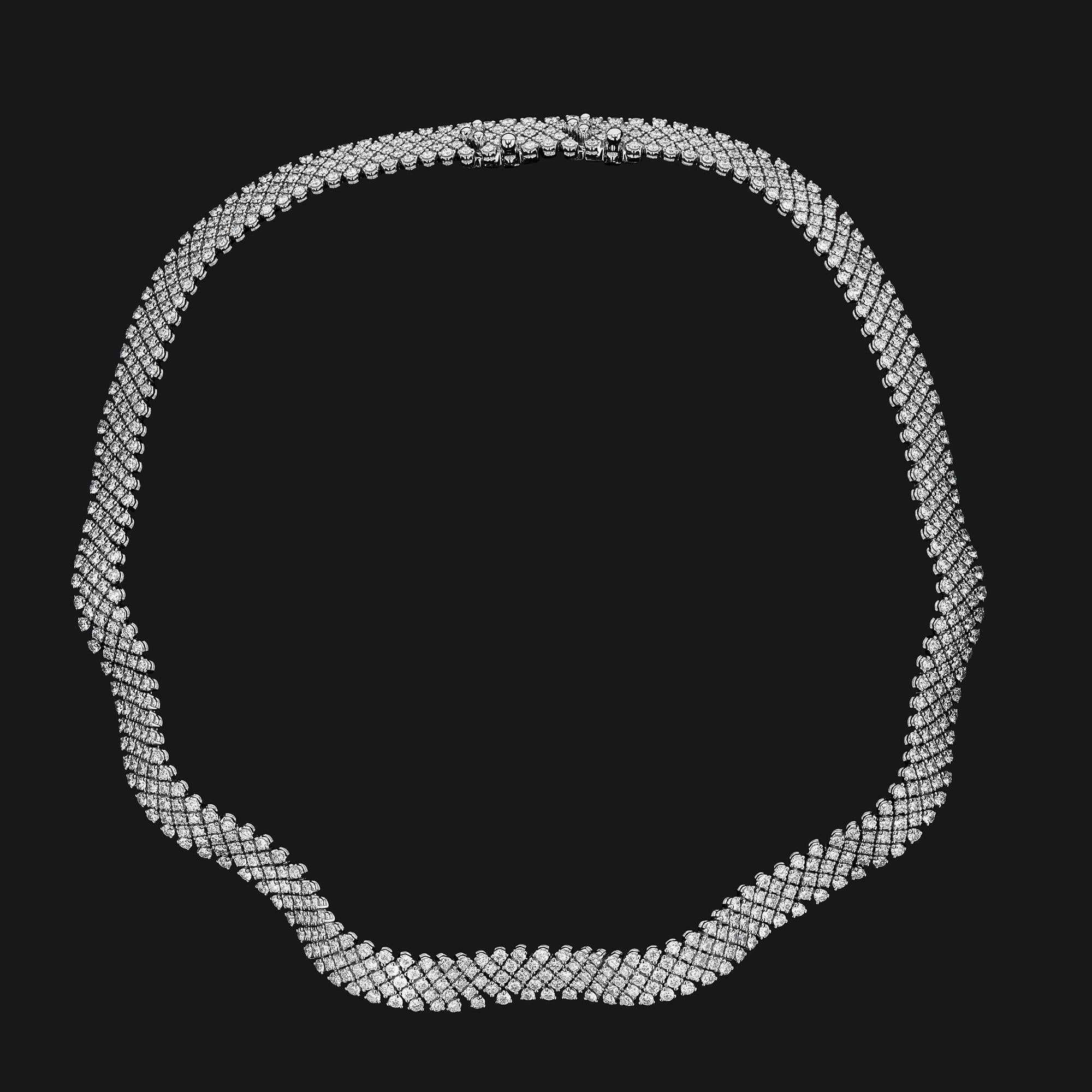 Vintage 18kt White Gold Diamond Ribbon necklace with 712 round full cut stones. They have a total carat weight of  17.80. The diamonds are G-H in color & VS in clarity. The diamonds are all prong set in 5 rows with a curved ribbon like pattern.