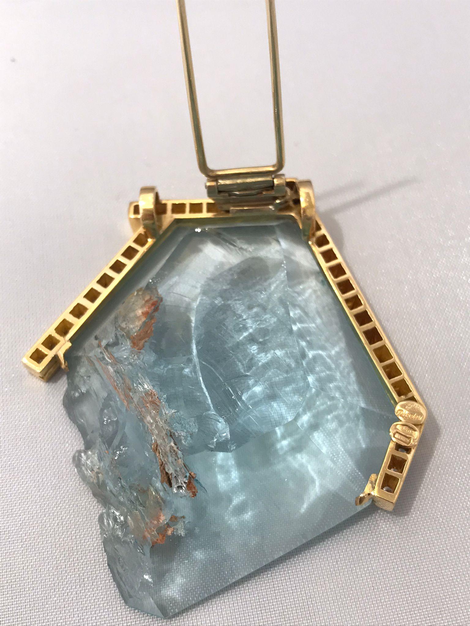 Splash. 1.45 carats of aquamarine partially faceted to leave a corner of rough crystal that enhances the naturalness of aquamarine. Framed by diamonds set in 18KT rose gold.

Thanks to the rings on the back of the setting it may be worn as a pendant