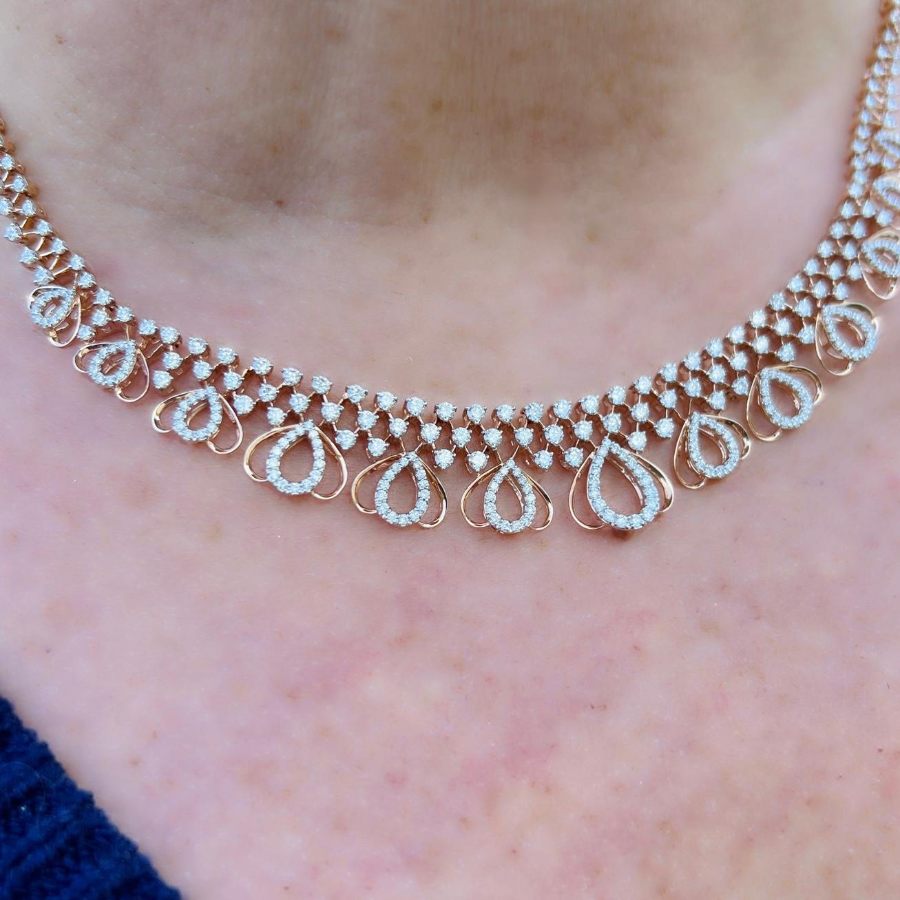An absolute beauty! This 18 karat rose gold choker necklace features 286 sparkling white diamonds weighing a total of approximately 3.72 carats. The unique design features an X cross pattern design with multiple tear drop designs suspended from the
