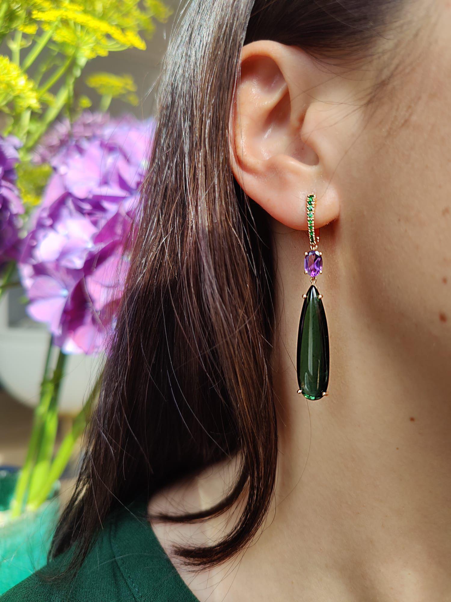 Add some colour with these beautiful drop earrings. Set with high quality green tourmalines in a dangling silhouette that sways as you gesture and laugh. The hook fastenings are traced with tsavorites to give the purple amethyst extra illumination.