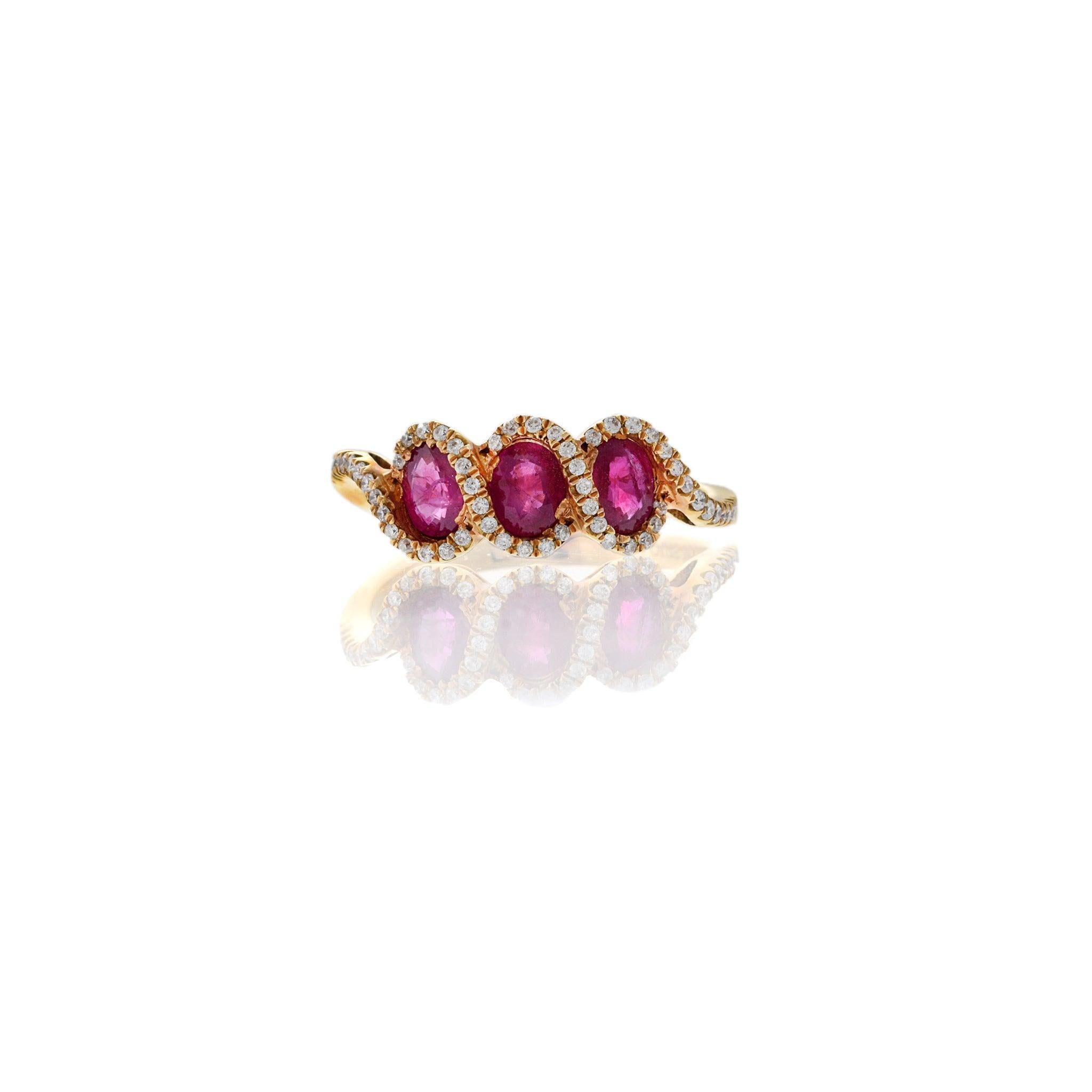 This vibrant three-stone ring offers a rich pop of color in a refined setting. Crafted in 18KT rose gold, it features three vivid oval rubies totaling 1.05 carats, each surrounded by a delicate halo of round brilliant cut diamonds. The diamonds
