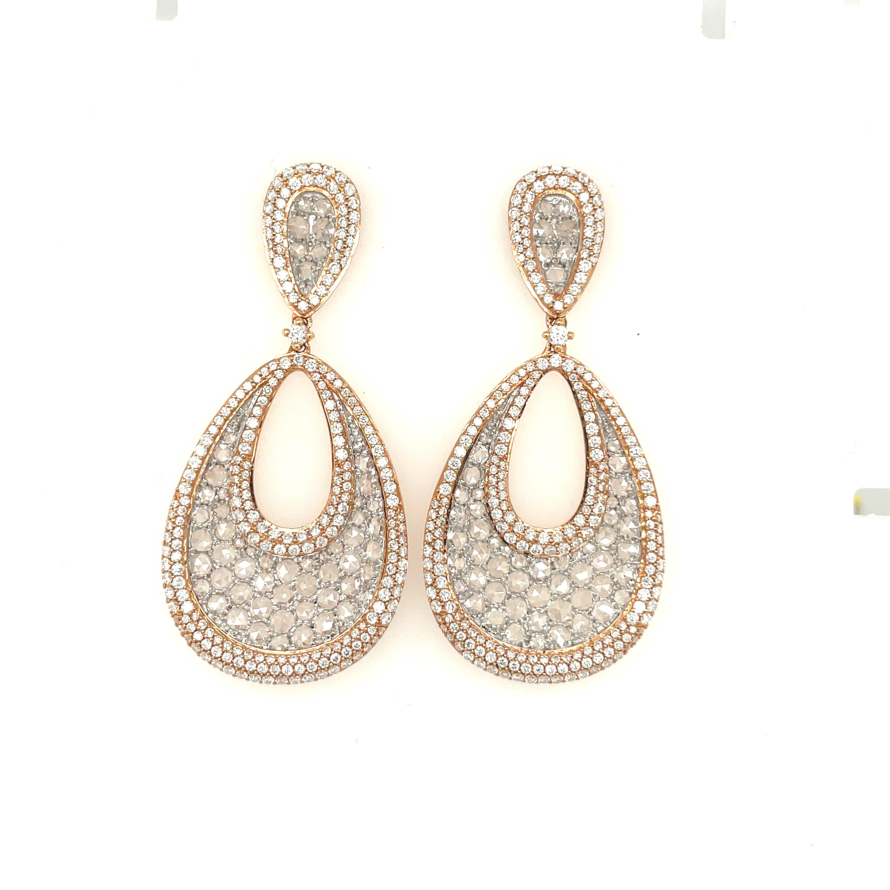 This stunning pair of hanging earrings are set with 2.70 carats of round diamonds surround 2.95 carats of rose-cut diamonds. The sparkle of the diamonds are enhanced by the combination of diamond cuts, as well as the combination of golds.

Set in