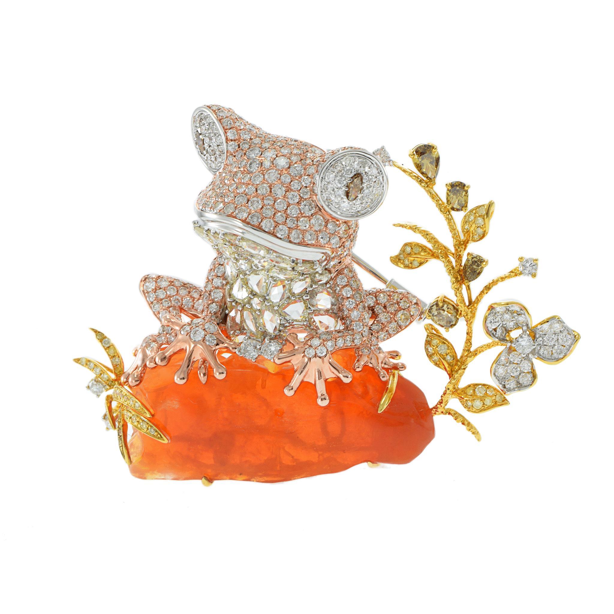 This exceptional 18KT tri-color gold frog brooch is a true masterpiece of fine jewelry design, featuring a striking 43.36 carat Mexican fire opal as the vibrant base, supporting an intricately crafted frog encrusted with 7.87 carats of rose,
