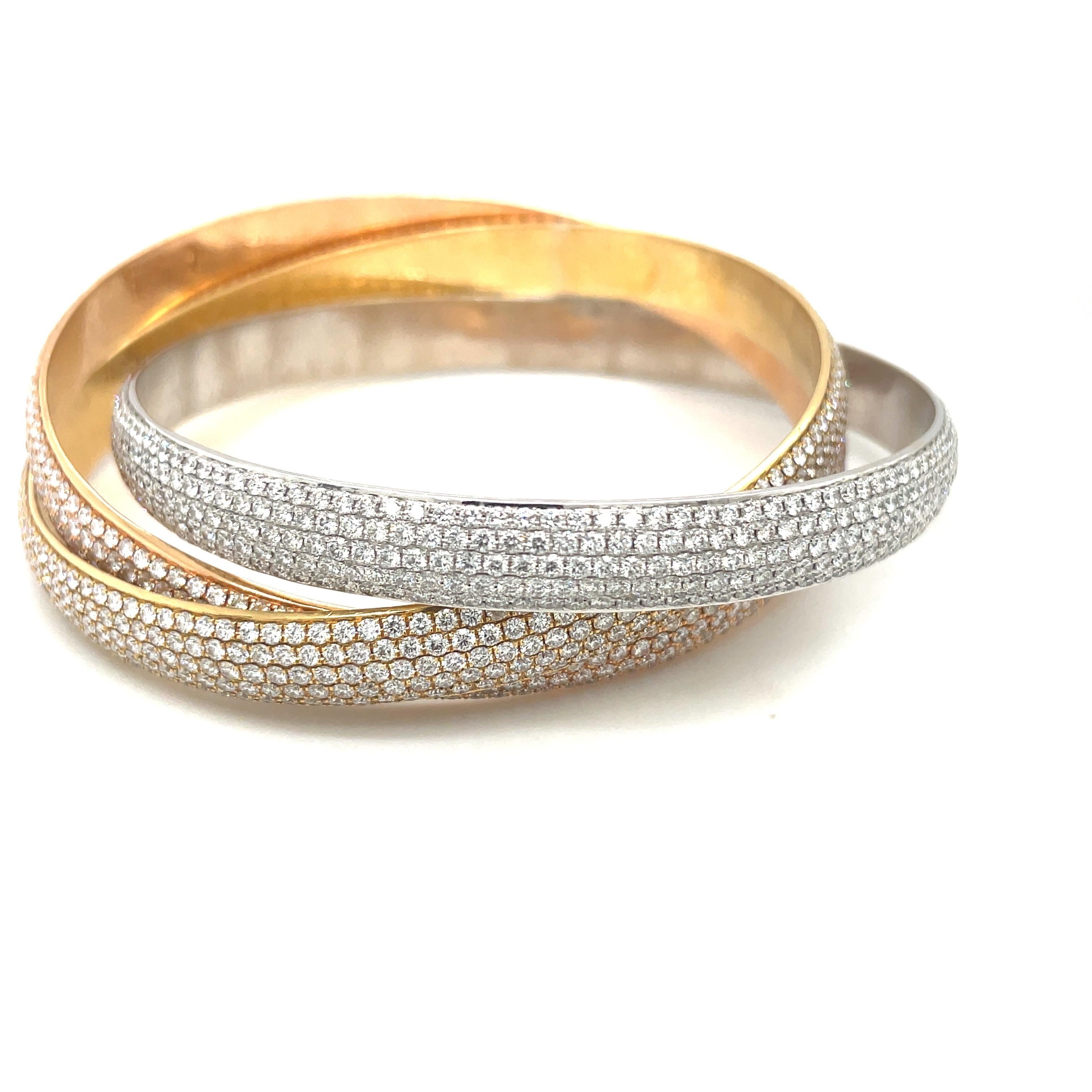 Designed in 18 karat yellow, rose and white gold, this rolling bangle bracelet remains classic. The bangle bracelet is set with 28.00 carats of round brilliant diamonds. Each bracelet has 5 rows of diamonds.
The inside measurement is 2.5 