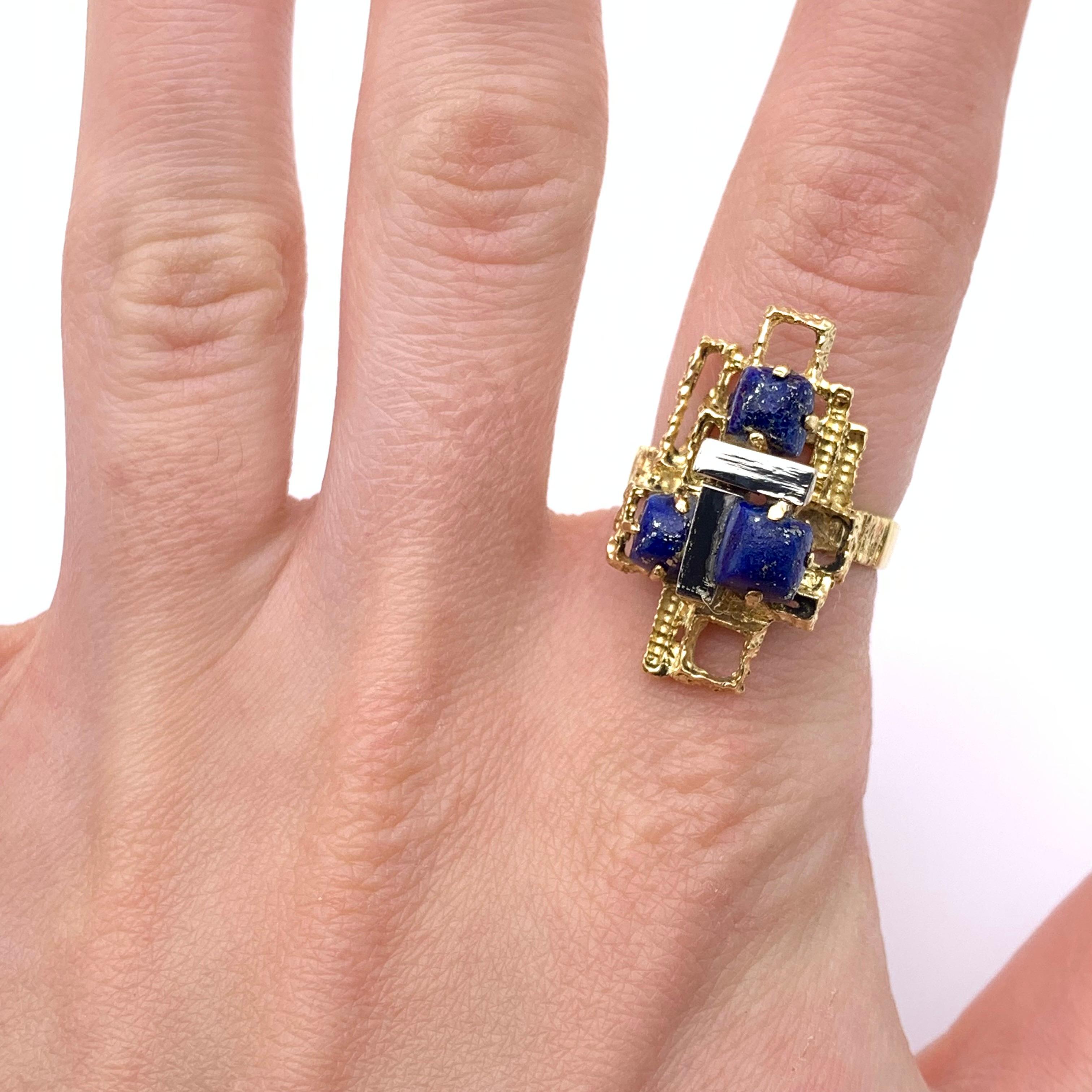 This ring is part of our estate collection. It comes from a Swiss goldsmith and is set in 18-karat yellow gold with white gold accents. It is prong-set with three sugarloaf cabochon lapis pieces. The ring is a size 6.5.