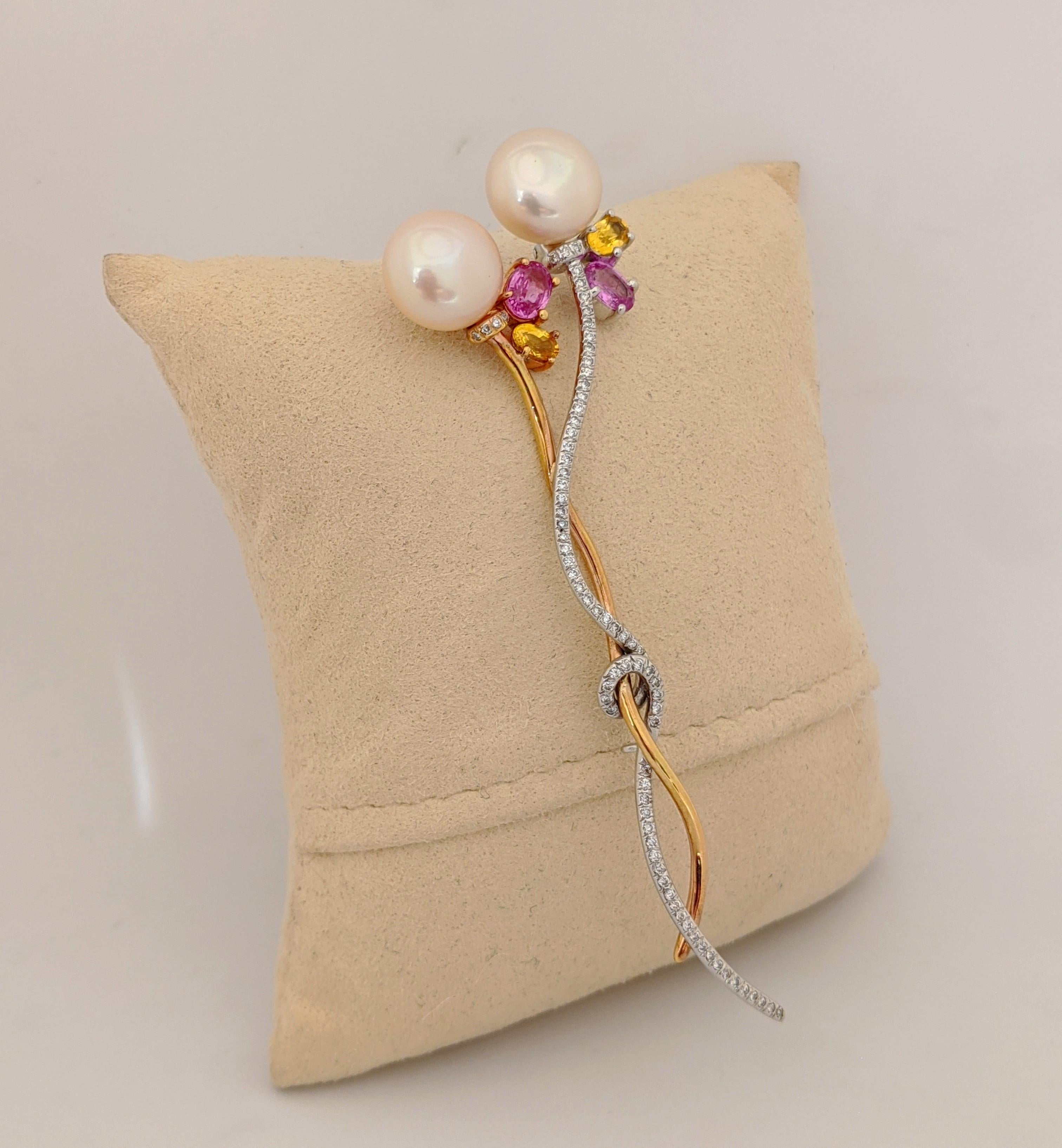 A lovely brooch to adorn a lapel or dress, 
This  brooch is designed with two freshwater pink pearls 11.2mm x 8.5mm.  Four Pink and Yellow oval shaped Sapphires are set under the pearls. The 18 karat white gold stem is set with round brilliant