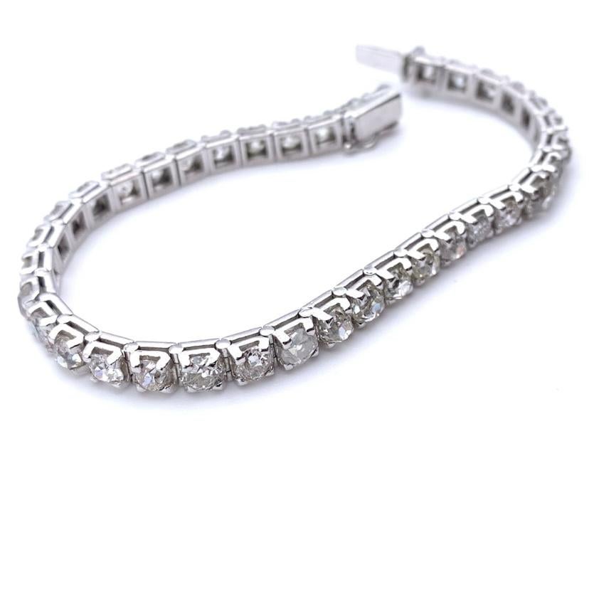 This tennis bracelet is part of our estate collection. It has so much character and is one of our favorites! It is set in 18-karat white gold and features 37 diamonds of various cuts and color grades. The diamonds measure approximately 11.5 carats