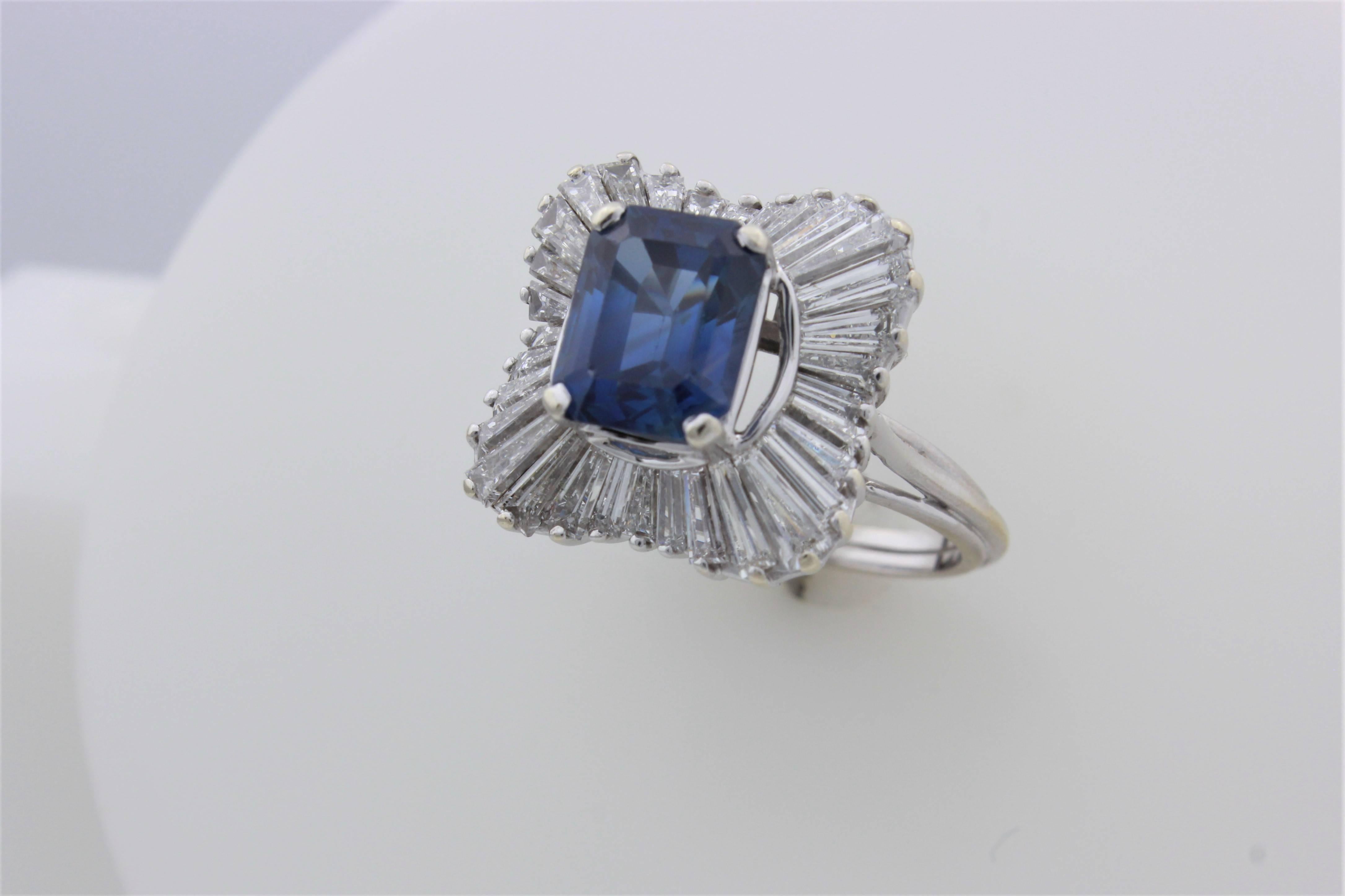 Stunning 18 karat white gold ballerina style ring with an approximately 3 1/2 carat emerald cut sapphire surrounded by approximately 4 carats of high quality (G-H color, VS clarity) baguettes!  Ring size is 6 1/2 and is sizeable.  