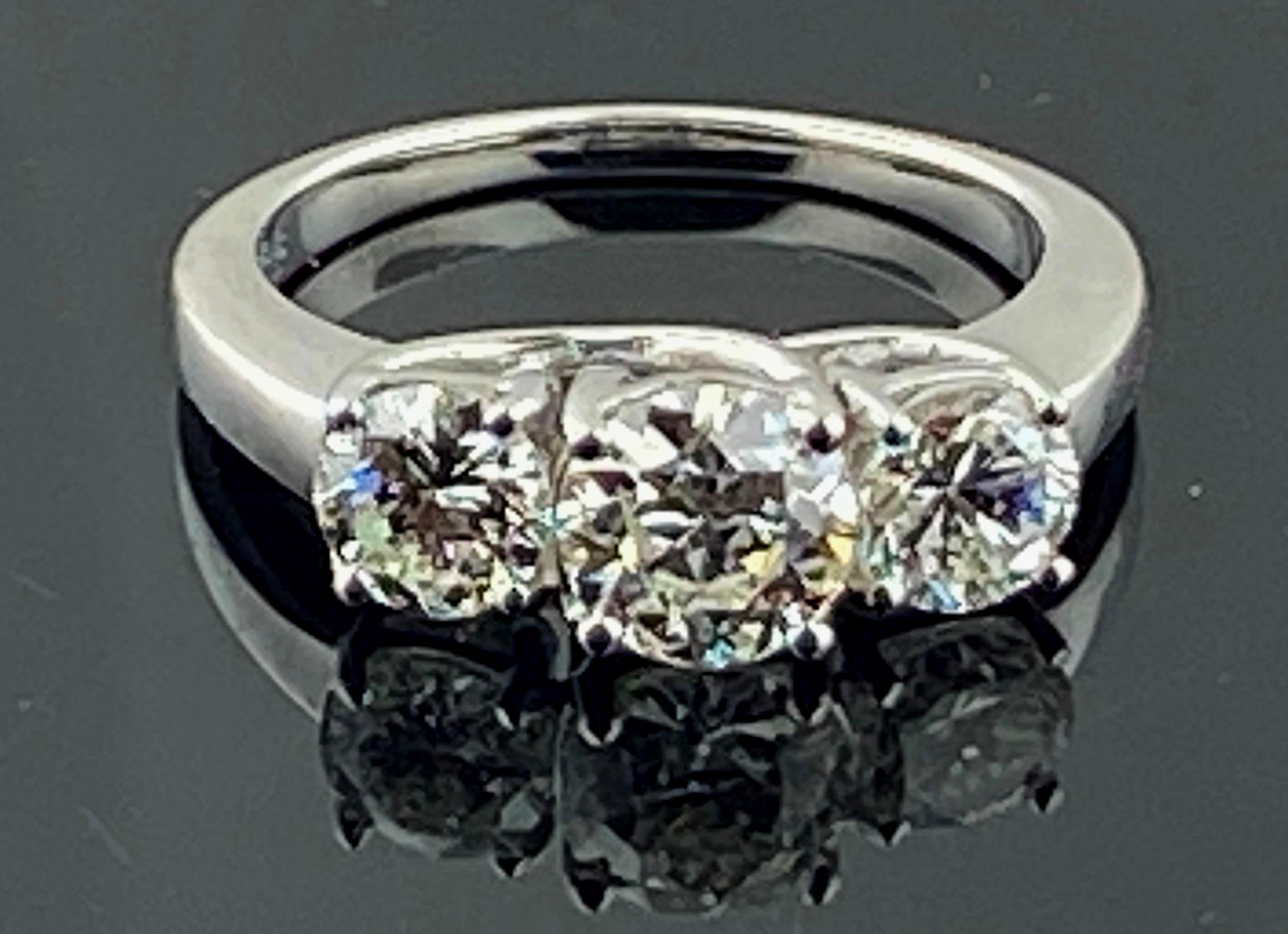 Set in 18 karat white gold, weighing 6.10 grams, are three round brilliant cut diamonds.  The center diamond is 1.08 carats, Color: H-I, Clarity: SI-2, on one side the diamond is 0.68 carats, Color: G-H, Clarity: SI-2 and on the other side the