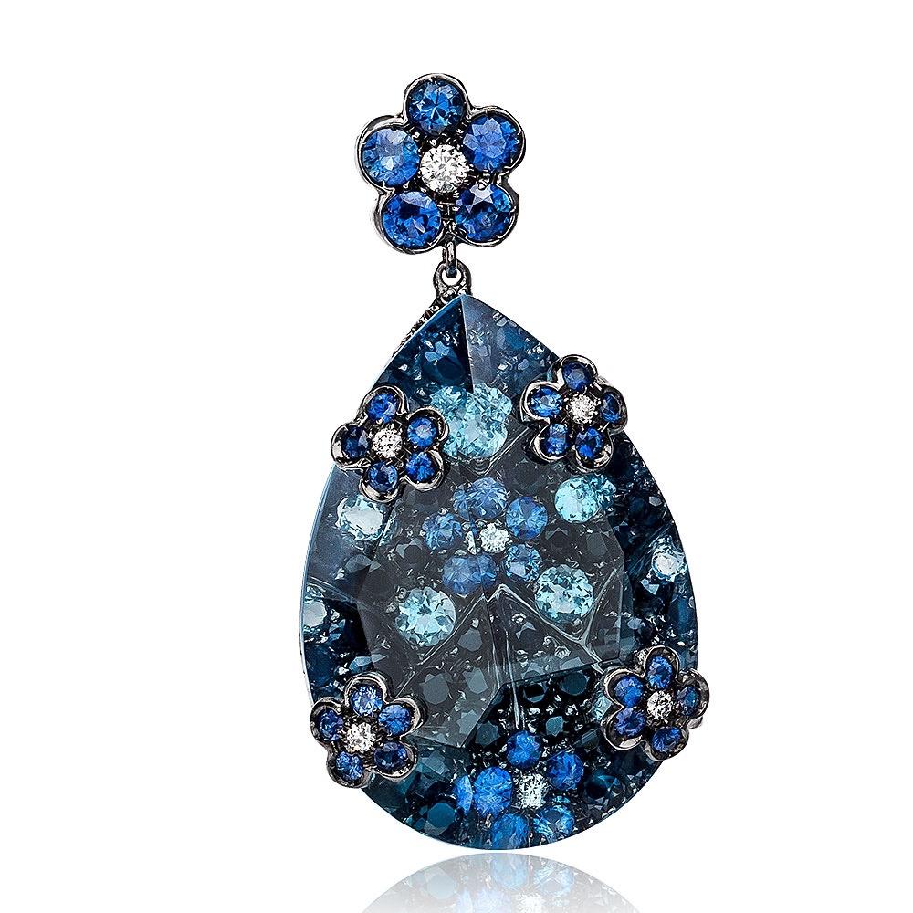 This stunning pair is composed of 1.70 carats of blue sapphire cluster flowers, surrounded by 2.90 carats of black sapphires and sprinkled with .65 carats of aqua. This detailed pair is overlayed with 32.80 carats of blue topaz, which magnifies the