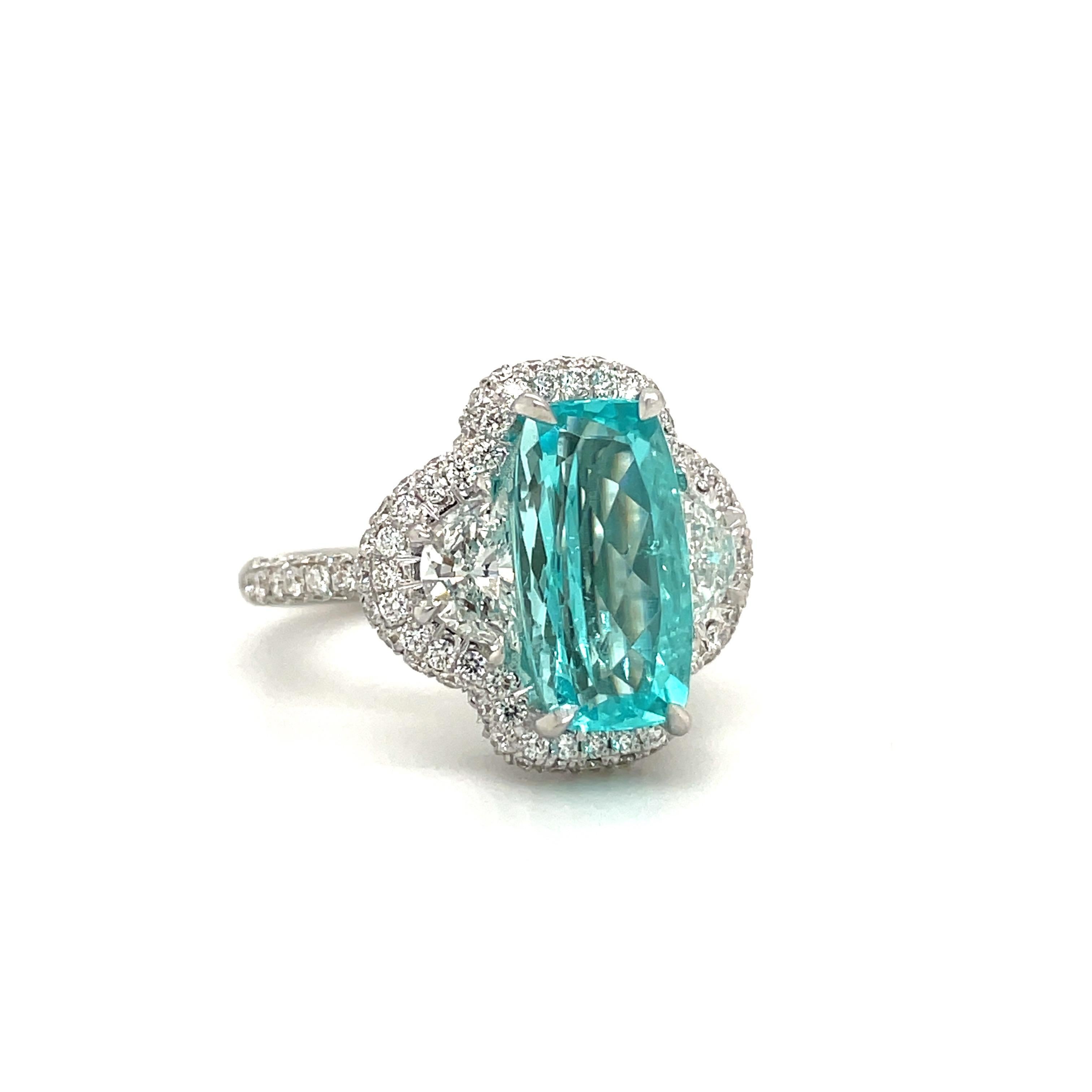 Magnificent 18 karat white gold ring exquisitely set with a 3.94 carat rectangular Paraiba Tourmaline. The center stone is flanked with 0.83 carats half moon diamonds . The center stones are surrounded by a beautiful pave diamond setting, which