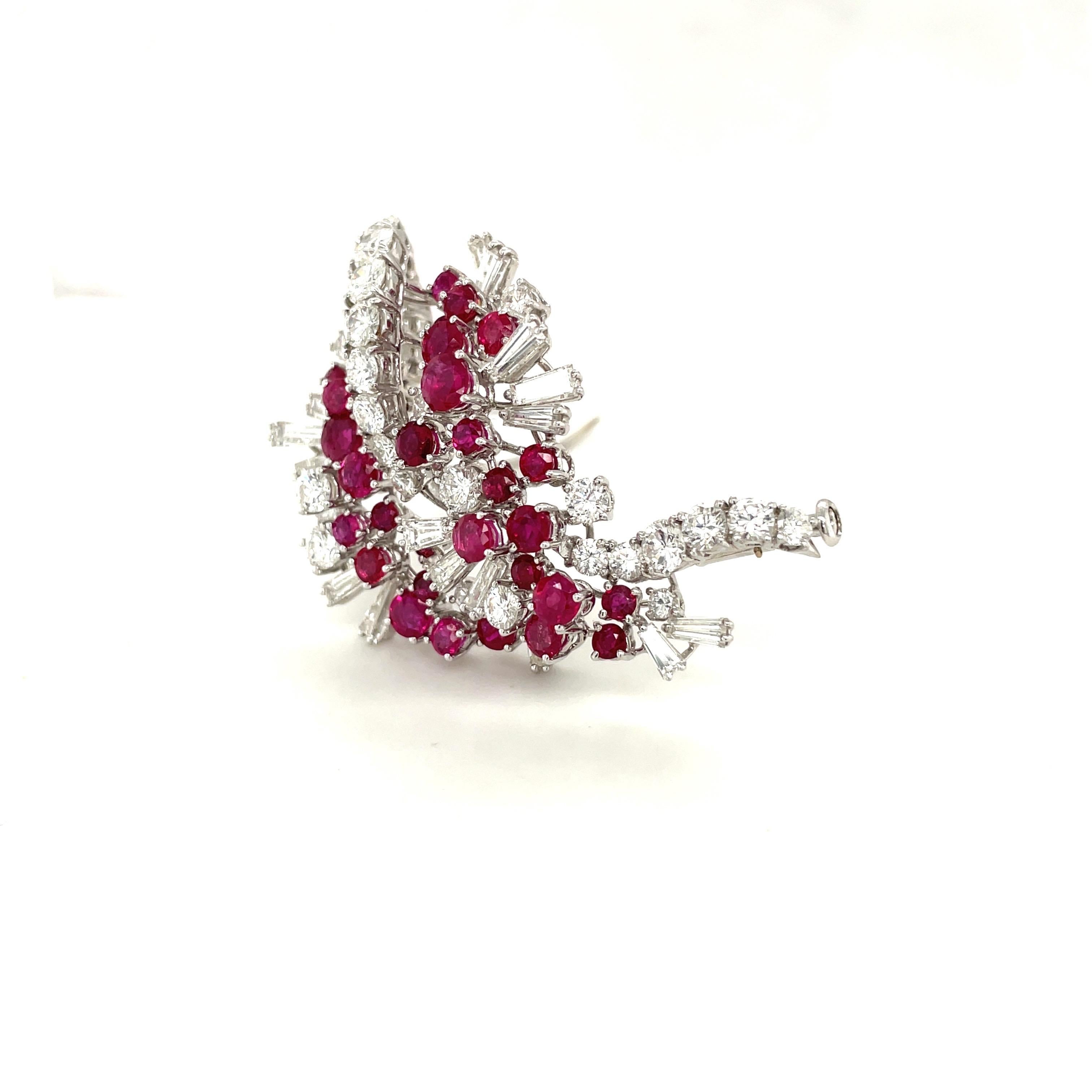 Magnificent 18 karat white gold diamond and ruby brooch. Round brilliant diamonds and rubies along with diamond baguettes are set like a flowing ribbon in this elegant classic brooch. The brooch measures 1-3/4