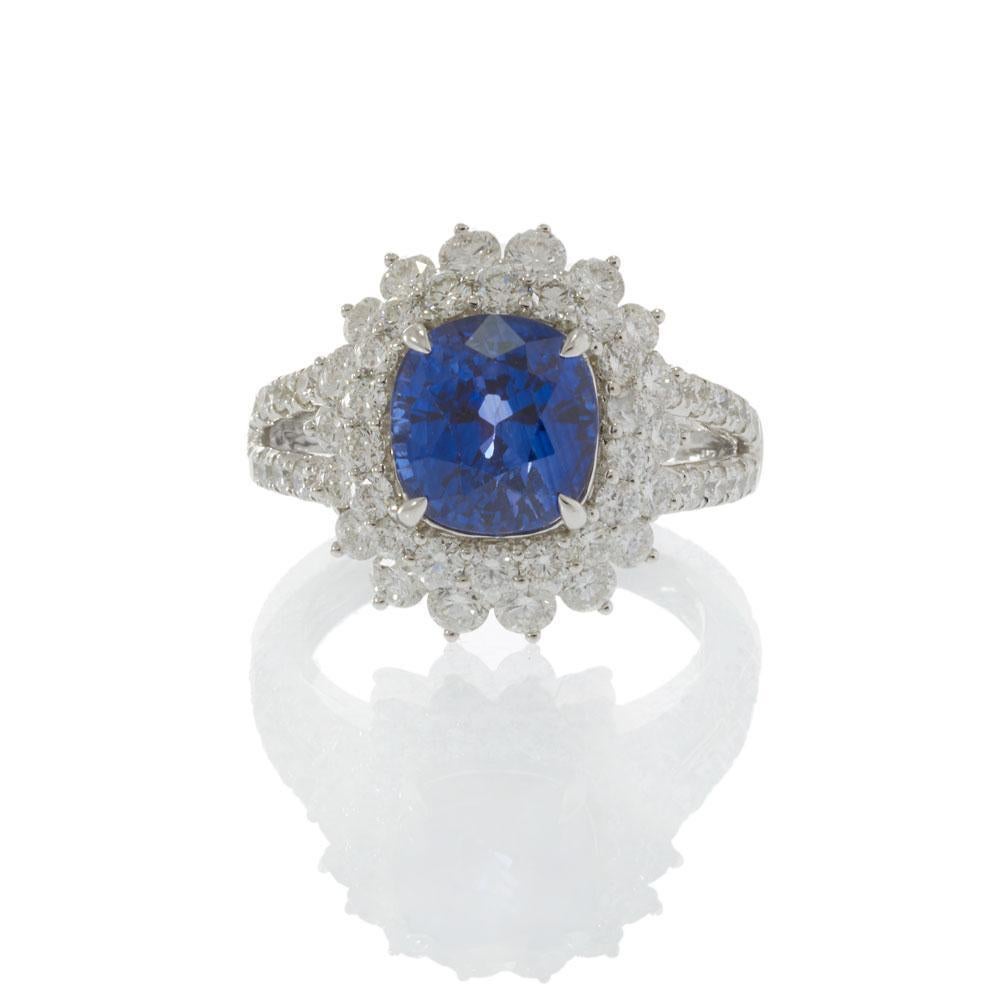 Cette bague de cocktail majestueuse est centrée sur un saphir coussin de 4,89 carats, entouré d'un double halo resplendissant de diamants ronds de taille brillant totalisant 2,14 carats. Le design de la tige fendue est méticuleusement pavé de