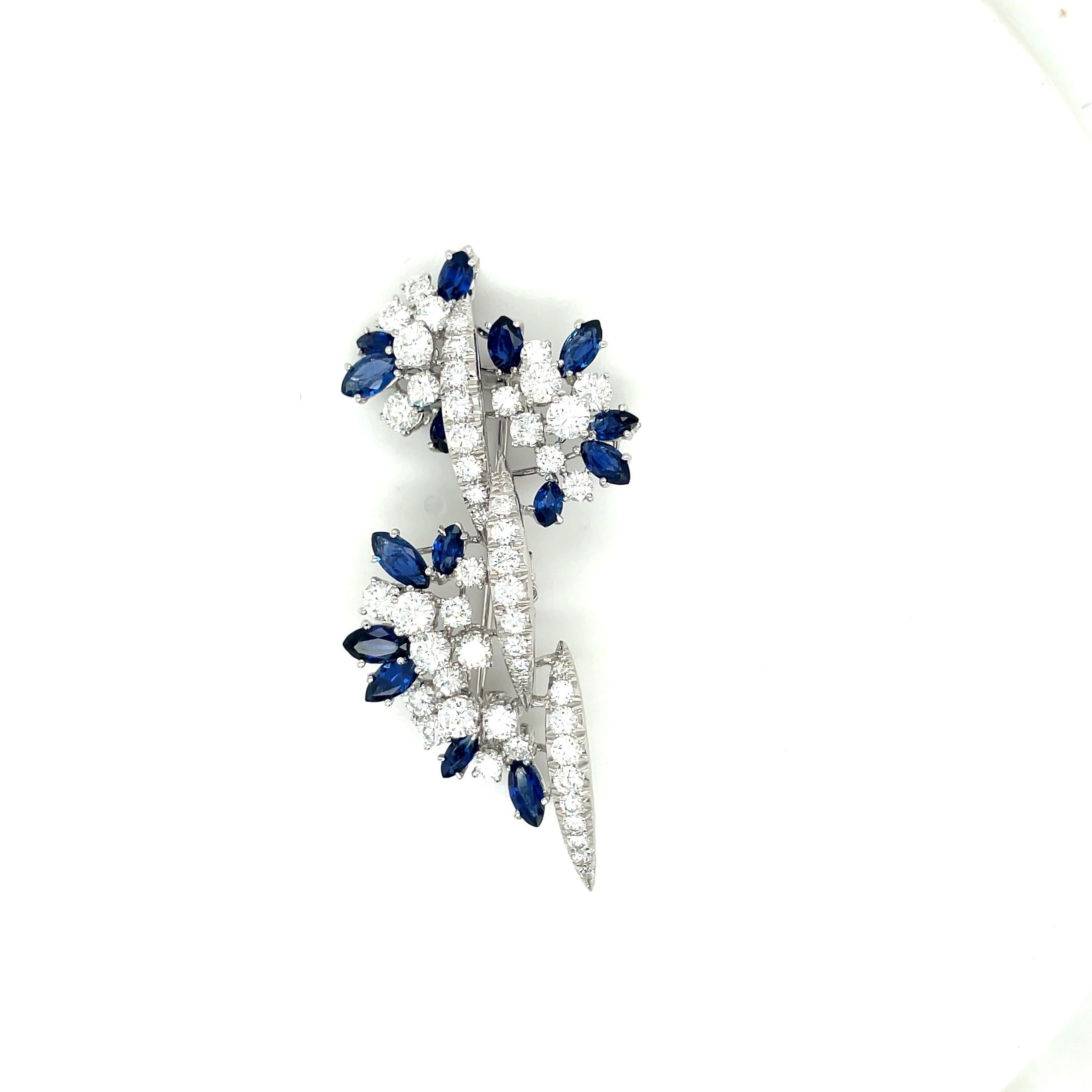 Beautiful 18 karat white gold classic brooch. This brooch is magnificently set with 50 round brilliant diamonds and 15 marquis blue sapphires. The 2.5