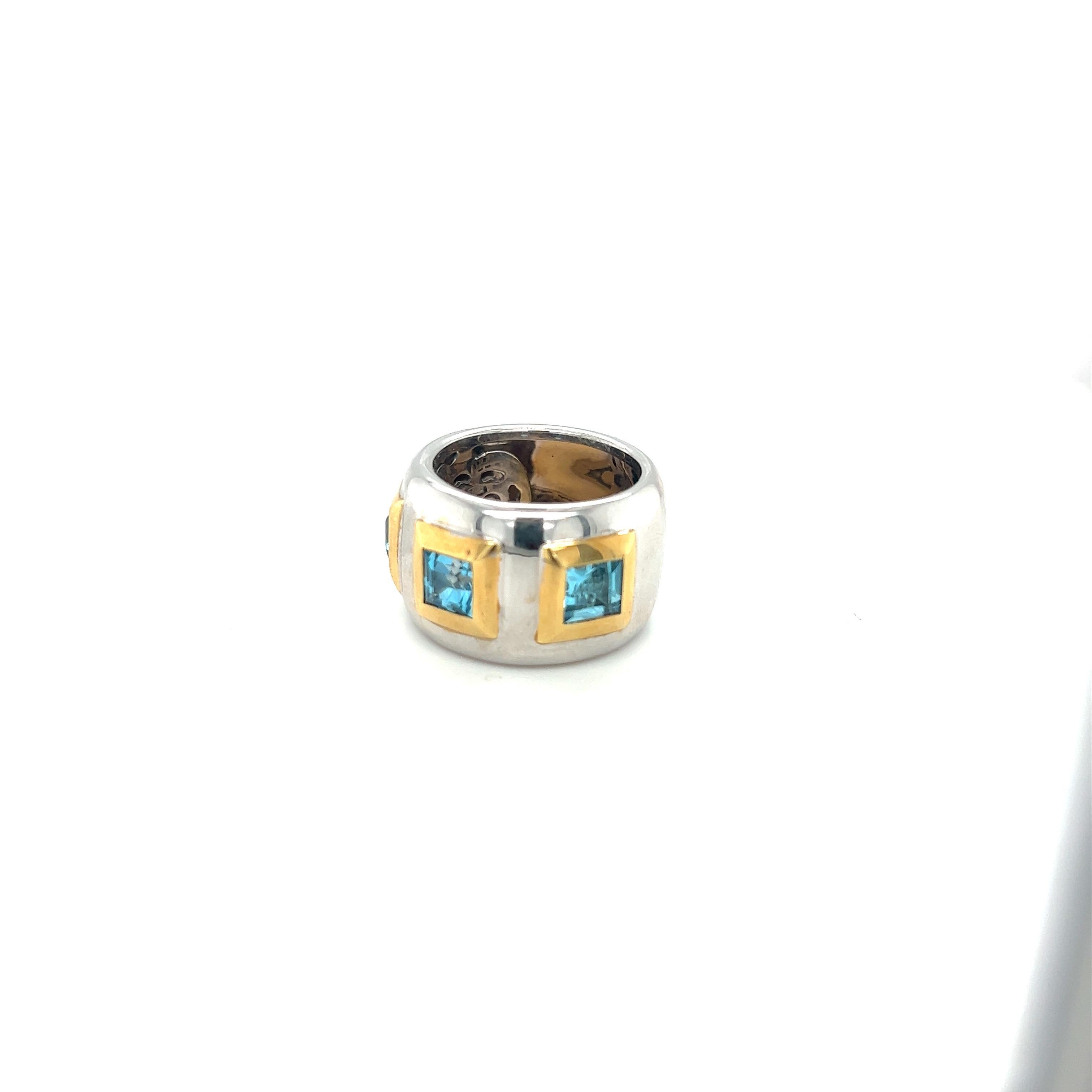 Modern band ring crafted in 18 karat white gold. The band features 3 square emerald cut blue topaz stones set in 18 karat yellow gold wide bezels.
The band measures 14mm in width and is finger size 7
Stamped 750