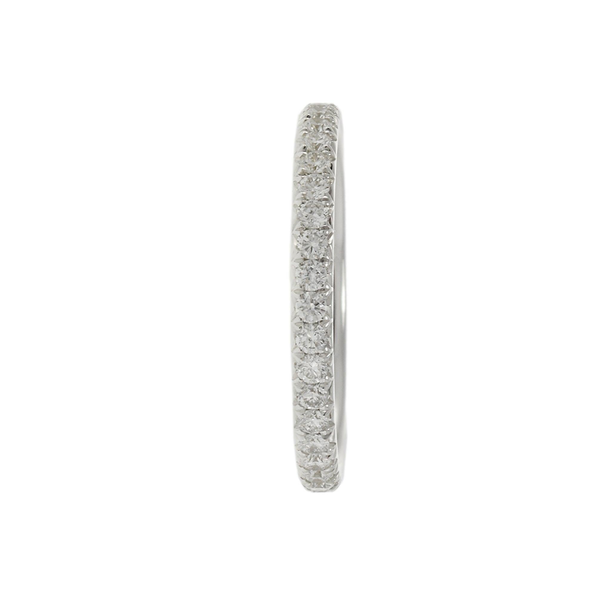 This elegant 18KT white gold eternity band is set with a continuous circle of brilliant round cut diamonds, totaling 0.70 carats. Perfect as a wedding band or a sparkling addition to a ring stack, this band exudes timeless sophistication. With a